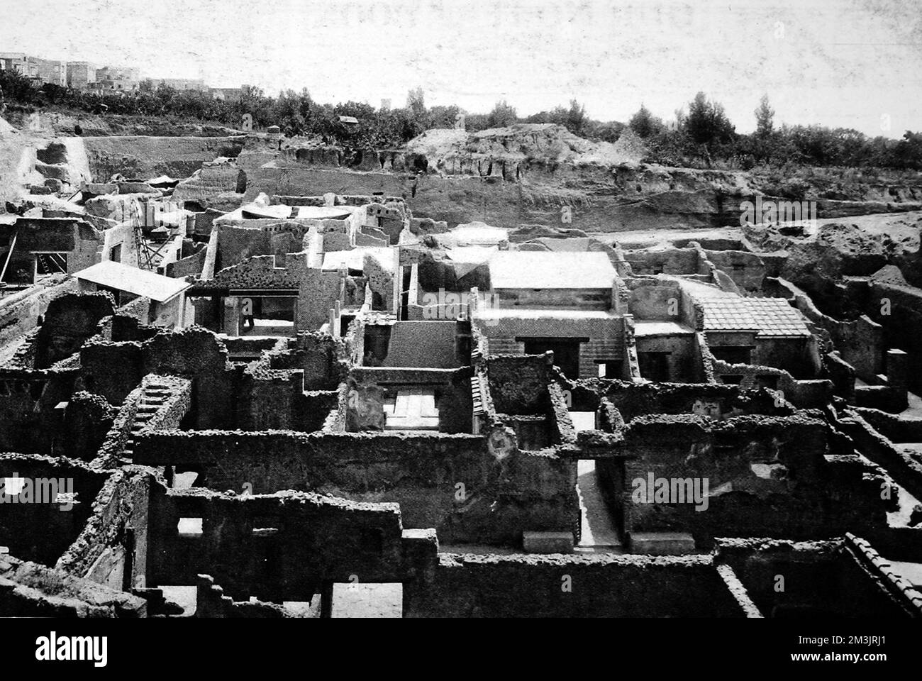 Eine antike römische Stadt, die unter 30 Fuß erstarrtem Schlamm aus dem großen Ausbruch des Vesuv im Jahr 79 n. Chr. ausgegraben wurde Das erste Jahr der Ausgrabungen in Herculaneum mit ausgegrabenen Häusern am westlichen Ende und neuen Grabungen in Richtung Zentrum. Viele Häuser haben Holzmöbel, sorgfältig geschnitzt und teilweise mit Holztreppen intakt. Stockfoto