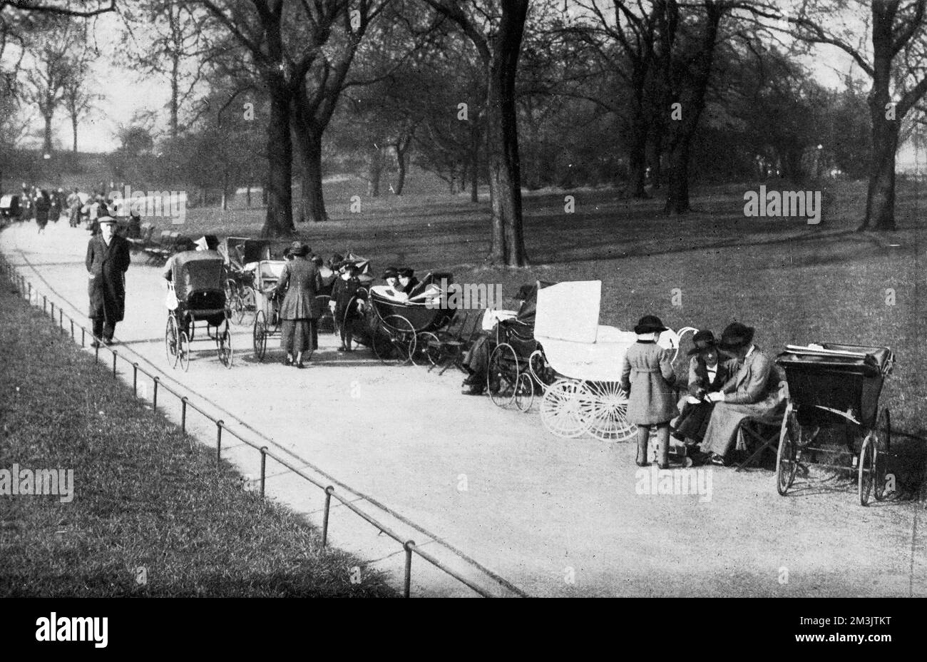 Ein Foto, auf dem Kinder und ihre Krankenschwestern das Wetter auf einem Nachmittagsspaziergang genießen. Datum: 1920 Stockfoto