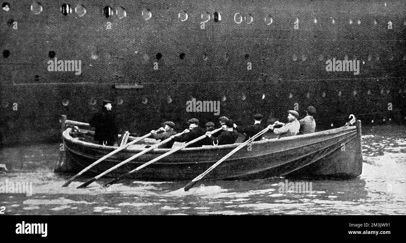 Einige der Besatzungen der White Star Liner SS „Olympic's“ rudern auf einem der Rettungsboote des Schiffes. Nach der Katastrophe auf der "Titanic" wurden weitere Berthon-Rettungsboote auf die "Olympic" gesetzt. Einige der Besatzungsmitglieder der „Olympischen Spiele“ waren jedoch der Ansicht, dass diese zusammenklappbaren Rettungsboote (wie abgebildet) nicht gut genug waren, und unternahmen Arbeitskampf. „Olympic“ wurde 1910 von Harland und Wolff, Belfast, gestartet und wurde mit einer Länge von 882 Fuß und einem Gewicht von 45.000 Tonnen zum größten Schiff, das damals über Wasser flog. Sie wurde von 1911 bis 1914 auf dem Atlantikdienst zwischen Großbritannien und Nordamerika operiert. Fol Stockfoto