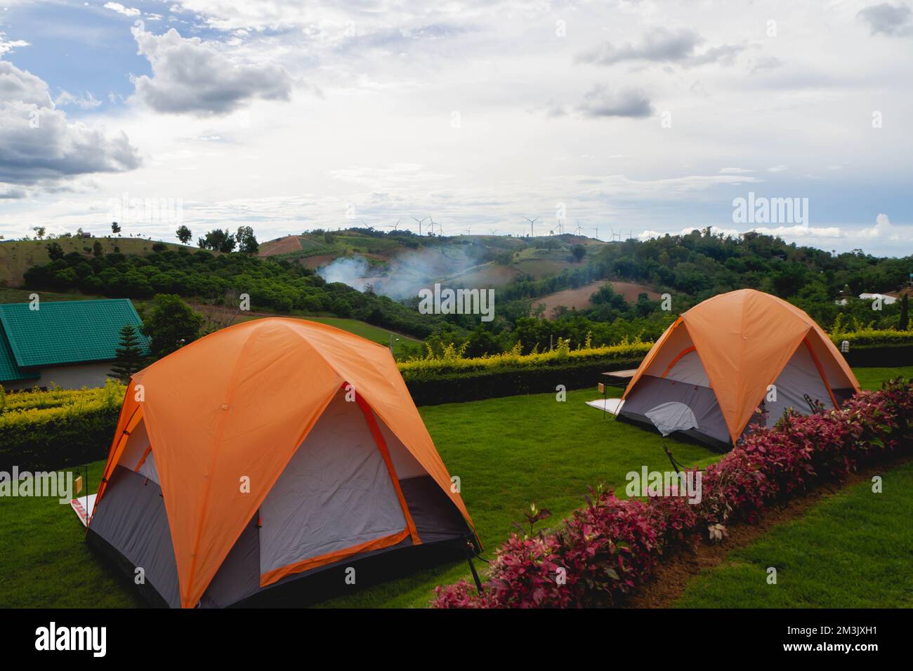 Orangefarbenes Zelt auf dem Feld in den Bergen Stockfoto