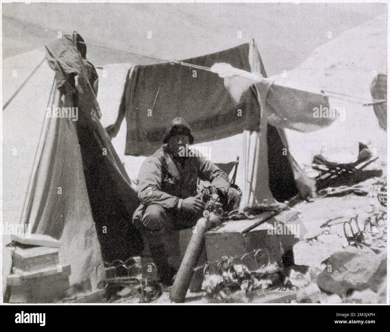 Andrew Comyn Irvine (1902-24), britischer Bergsteiger, arbeitet an einer Sauerstoffflasche im Everest Expeditionslager 1924. Irvine, obwohl ein relativ unerfahrener Kletterer, war ein Experte in der Wartung und Reparatur von Sauerstofftanks, und wegen dieser Fähigkeit wurde er ausgewählt, George Leigh Mallory für ihren tödlichen Anschlag auf den Everest zu begleiten. Stockfoto