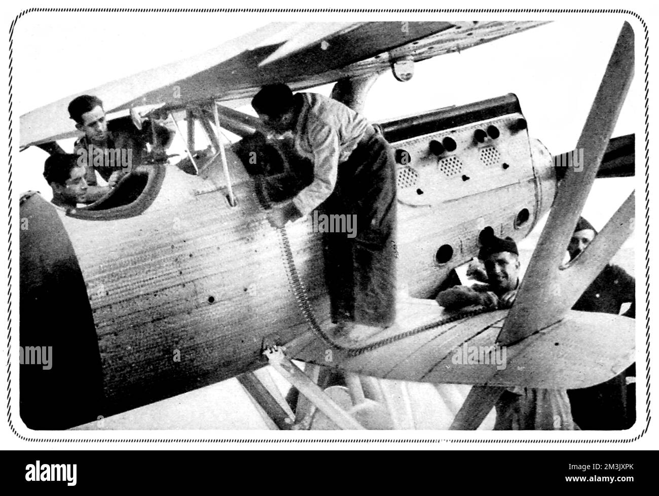 Das Foto zeigt Mitglieder der republikanischen Luftwaffe, die während der frühen Stadien des Bürgerkriegs 1936 Maschinengewehre eines ihrer Doppelflugzeuge in Irun, Nordspanien, beladen. Datum: 1936 Stockfoto