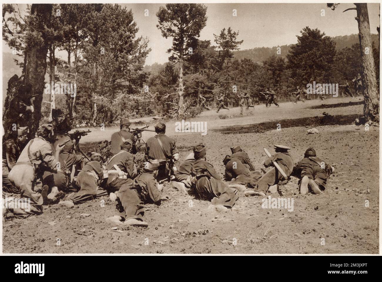 Ein Maschinengewehrabschnitt der republikanischen Armee (Vordergrund), der den Vormarsch einer Infanterieeinheit während der Kämpfe in den Guadarrama Hills in den frühen Stadien des Spanischen Bürgerkriegs abdeckte. Stockfoto