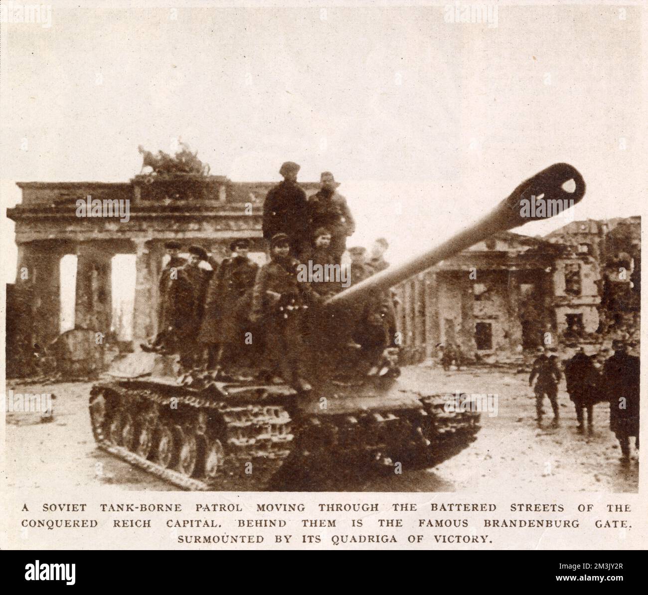 Ein sowjetischer Panzer, der sich durch Berlin bewegt, mit dem Brandenburger Tor im Hintergrund, Mai 1945. Berlin fiel am 2. Mai 1945 nach einer Schlacht, die 17 Tage dauerte, an die russische Armee. Angesichts des Verhaltens der Männer, die auf dem Panzer reiten, ist es sicher anzunehmen, dass dieses Foto nach der deutschen Kapitulation aufgenommen wurde. Stockfoto