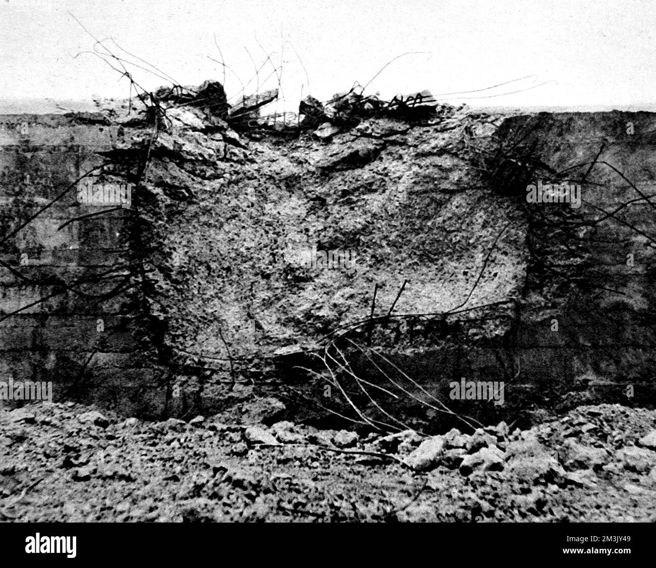 Der Schaden an einer Stahlbetonwand, verursacht durch eine Sprengladung in einem „fliegenden Abfalleimer“, Frankreich, 1944. Der Panzer der Churchill AVRE (Panzerwagen Royal Engineers) war mit einem Petard-Mörtel ausgestattet, der Bunker und Betonhochburgen angreifen sollte. Die vom Mörser abgefeuerte Ladung war allgemein als „fliegender Mülleimer“ bekannt. Datum: 1944 Stockfoto