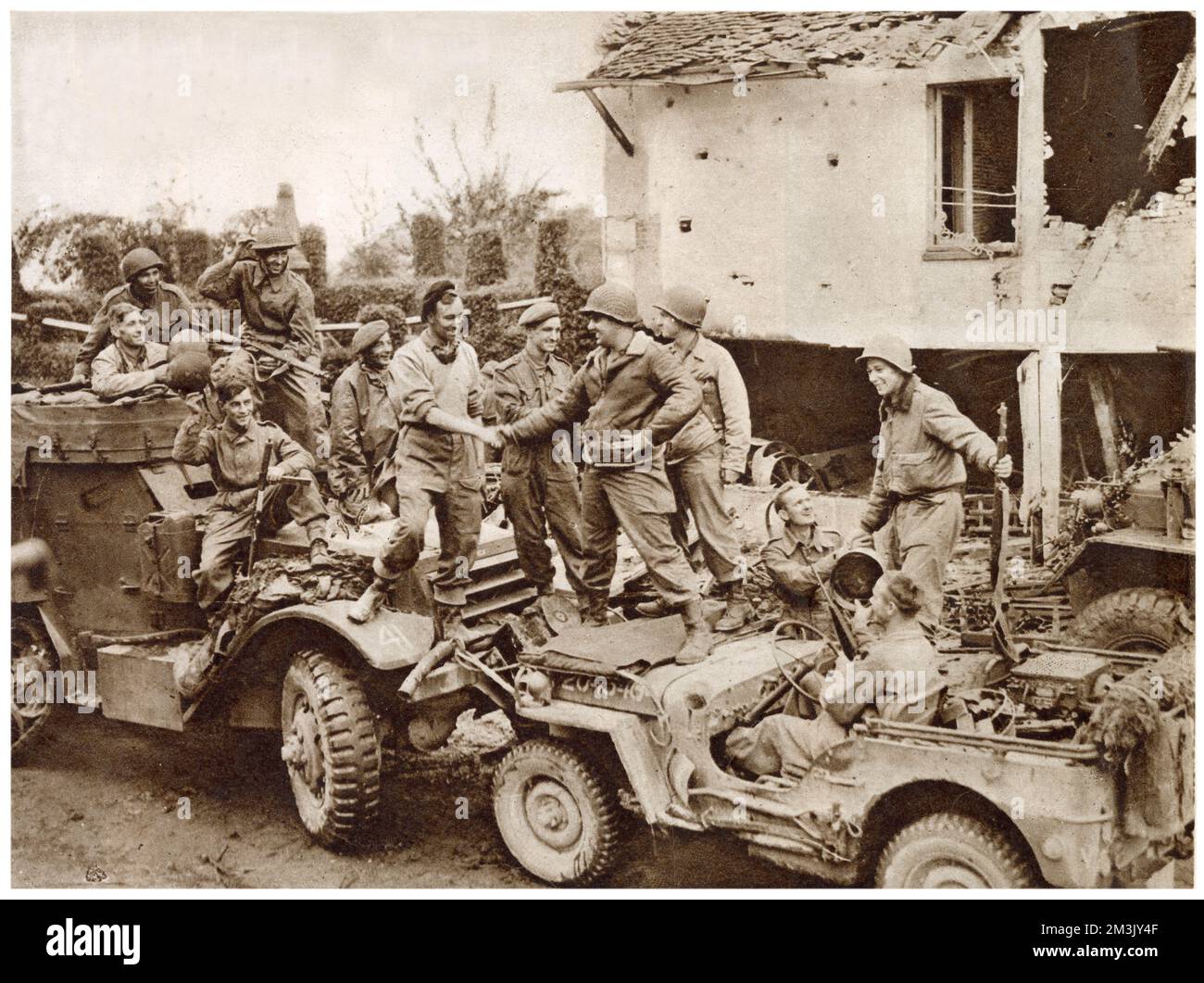 Das Treffen zwischen amerikanischen Truppen (rechts mit Jeep) und kanadischen Truppen (links mit Halbschiene), um die „Falaise Pocket“ auf der Straße zwischen Falaise und Argentan, Frankreich, 1944 zu schließen. Durch die Schließung der Lücke in Falaise hatten die alliierten Truppen ihren Versuch beendet, die deutsche Fünfte Armee und die Siebte Panzerarmee einzukreisen. Stockfoto
