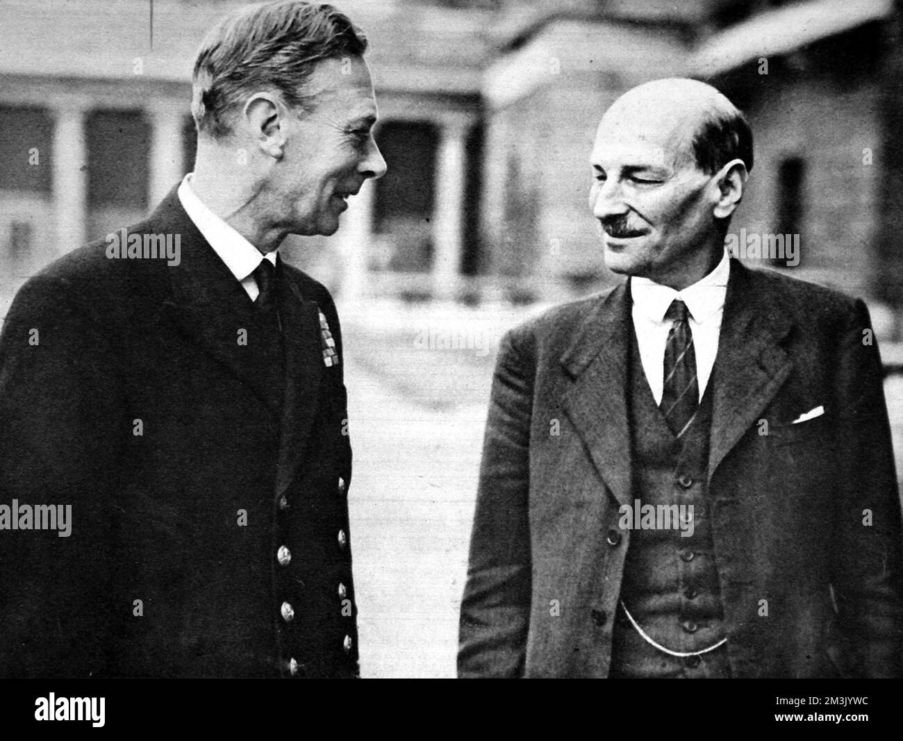 King George VI (1895 - 1952) und Clement Attlee, 1. Earl Attlee, (1883 - 1967) auf dem Gelände des Buckingham Palace, 1945. Attlee hatte gerade die Labour-Partei in den allgemeinen Wahlen zum Sieg geführt und damit Ministerpräsident geworden. 1945 Stockfoto