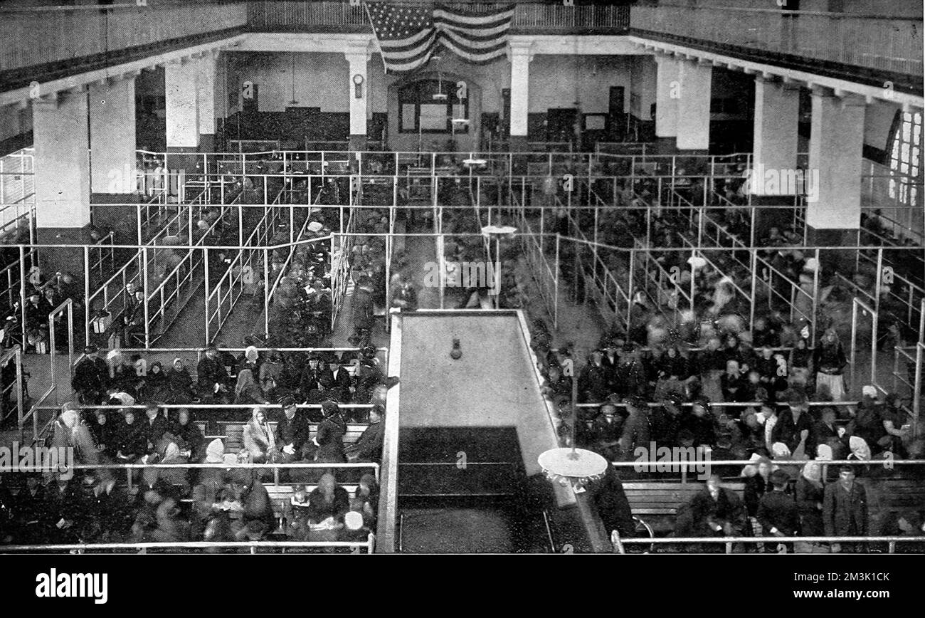 Das Foto zeigt die große Versammlungshalle des Einwanderungszentrums auf Ellis Island, New York, mit einer großen Anzahl von Einwanderern, die in Warteschlangen warten, 1911. Datum: 1911 Stockfoto