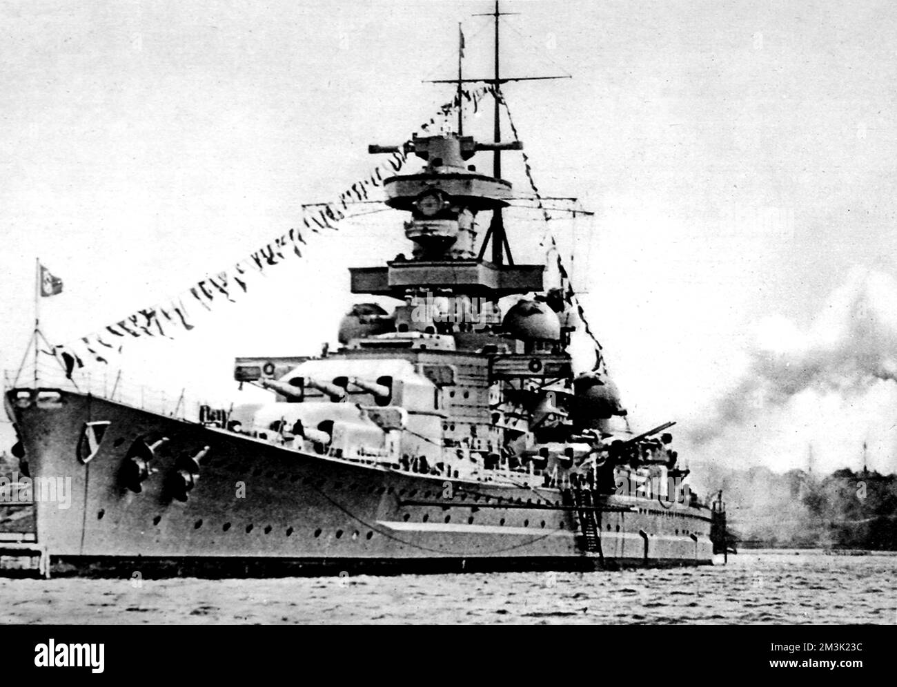 Das deutsche Schlachtschiff Scharnhorst, das anlässlich des Geburtstages von Adolf Hitler in einem unbekannten deutschen Hafen im Zweiten Weltkrieg salutiert. Die "Scharnhorst" wurde am 26.. Dezember 1943 bei der Schlacht am Nordkap von Royal Navy-Schiffen versenkt. Datum: 1943 Stockfoto