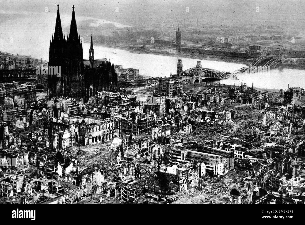 Luftaufnahme mit den Ruinen der Stadt Köln (Köln), mit dem Dom (links) und einer zerstörten Rheinbrücke (rechts), März 1945. Die Stadt wurde während des Vormarsches der amerikanischen Ersten Armee gegen die Nazi-Streitkräfte in der Gegend weitgehend zerstört. Datum: 1945 Stockfoto
