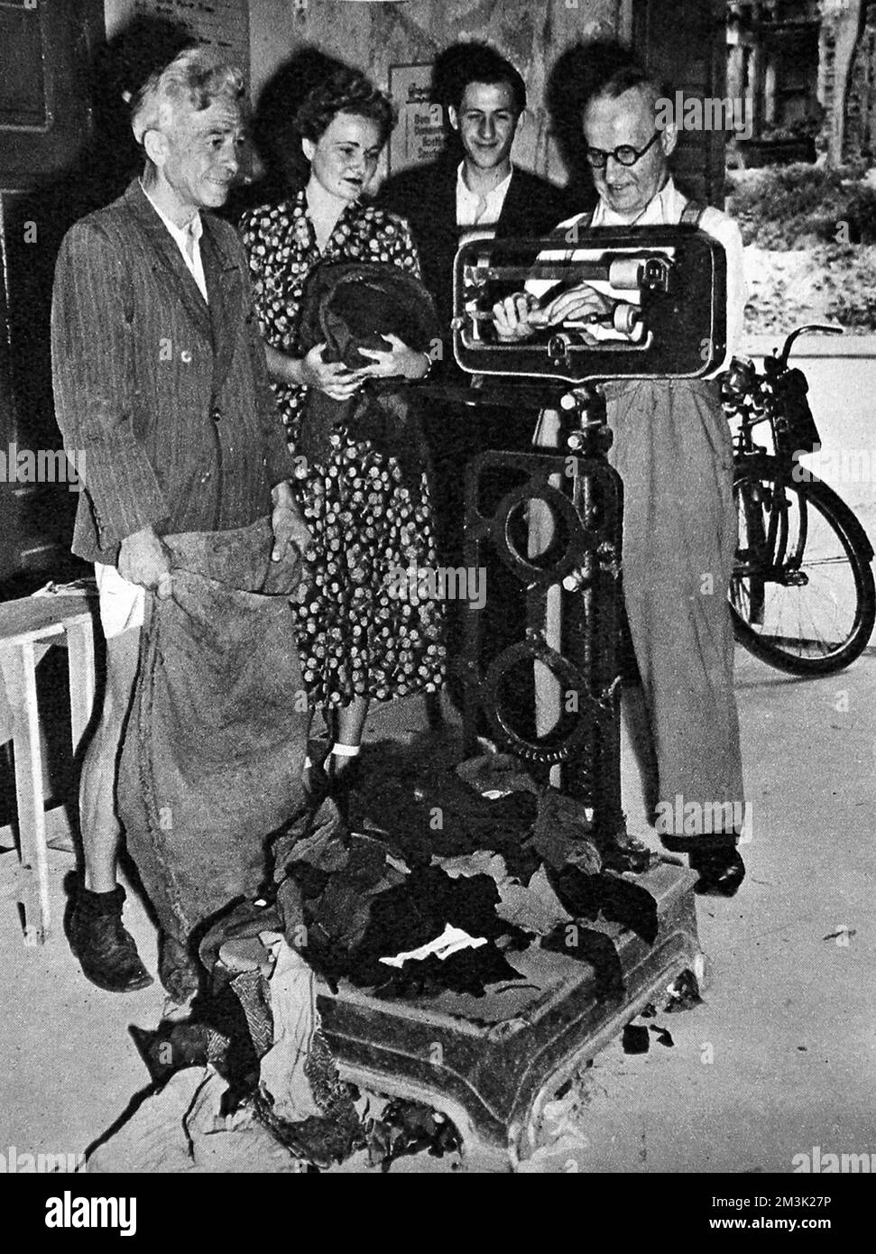 Das Foto zeigt, wie mehrere Bürger Westberlins ihre alte Wollbekleidung in ein Gebrauchtwarenlager in Berlin, August 1948, bringen. Die Kleidung wurde gewogen, dann wurden Genehmigungen für den Kauf neuer Kleidung mit einem entsprechenden Gewicht ausgestellt. Die sowjetische Blockade Westberlins bedeutete, dass ein Mangel an allen Verbrauchsgütern unvermeidlich war. Zwischen April 1948 und Mai 1949 verhängte Josef Stalin, Führer der UdSSR, eine Landblockade für Lieferungen von Westeuropa nach Westberlin. Als Reaktion darauf organisierten die britische und die amerikanische Regierung einen enormen Lufttransport, um Nahrungsmittel und andere lebenswichtige Güter zu liefern Stockfoto