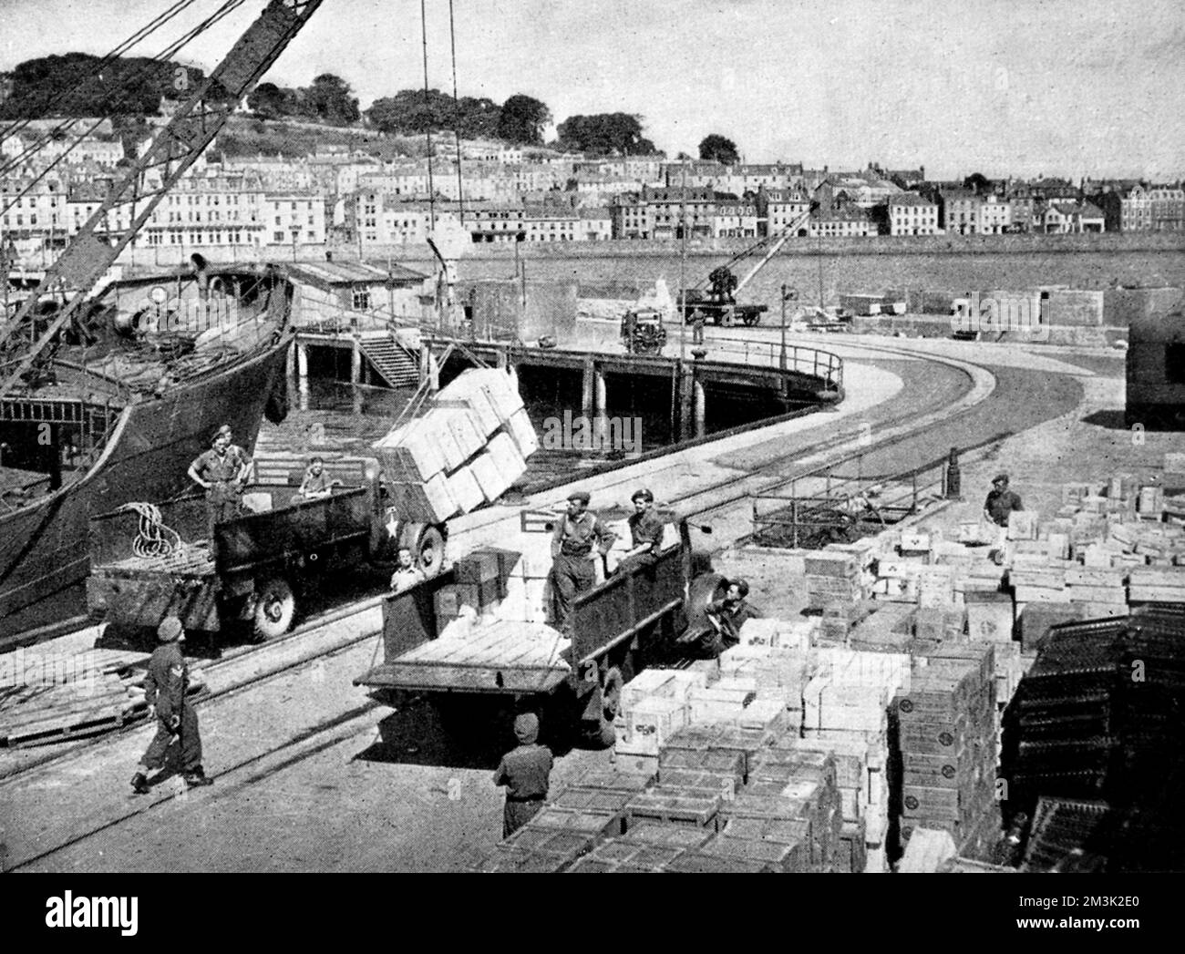 Das Foto zeigt das Entladen von Lebensmittelkisten in St. Peter Port, Guernsey, 1945. Nach fast fünf Jahren deutscher Besatzung verfügte die Zivilbevölkerung der Inseln über sehr wenig Nahrung, weshalb diese Lieferungen von Großbritannien aus transportiert werden mussten. 1945 Stockfoto