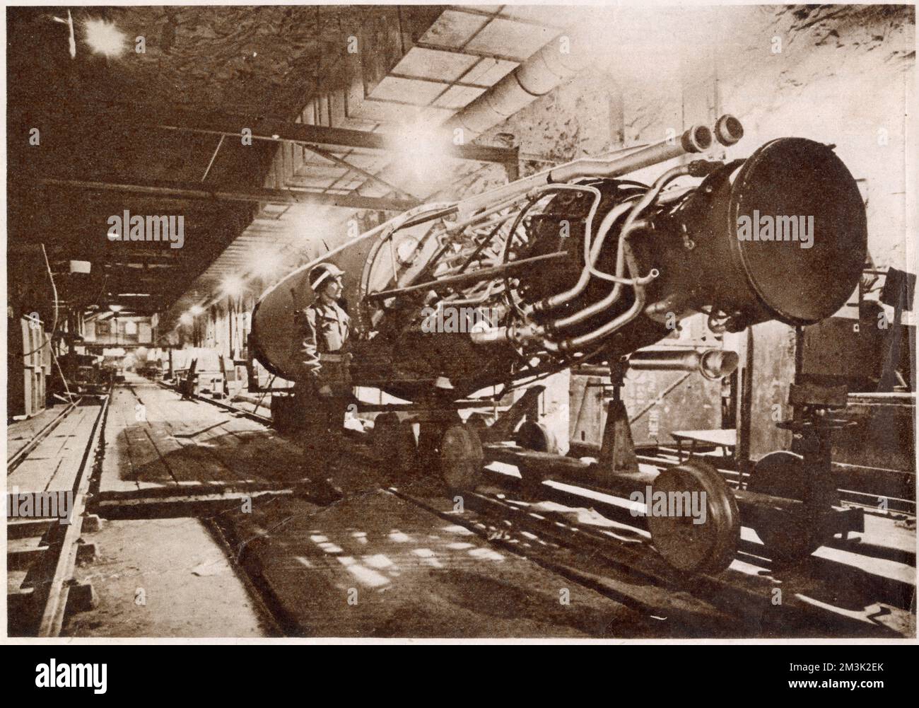 Ein amerikanischer Soldat der US First Army studiert eine teilweise montierte deutsche V-2-Rakete in einem unterirdischen Montagewerk in Nordhausen. Stockfoto