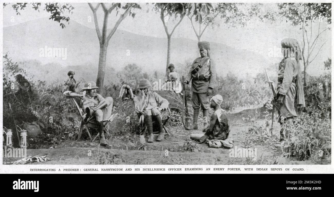 General Hannyngton und sein Geheimdienst-Offizier (sitzen auf den Stühlen) verhören einen feindlichen Portier (sitzen auf dem Boden) in deutschem Ostafrika, 1916. Zwei indische Sepoys bewachen den Gefangenen. Stockfoto