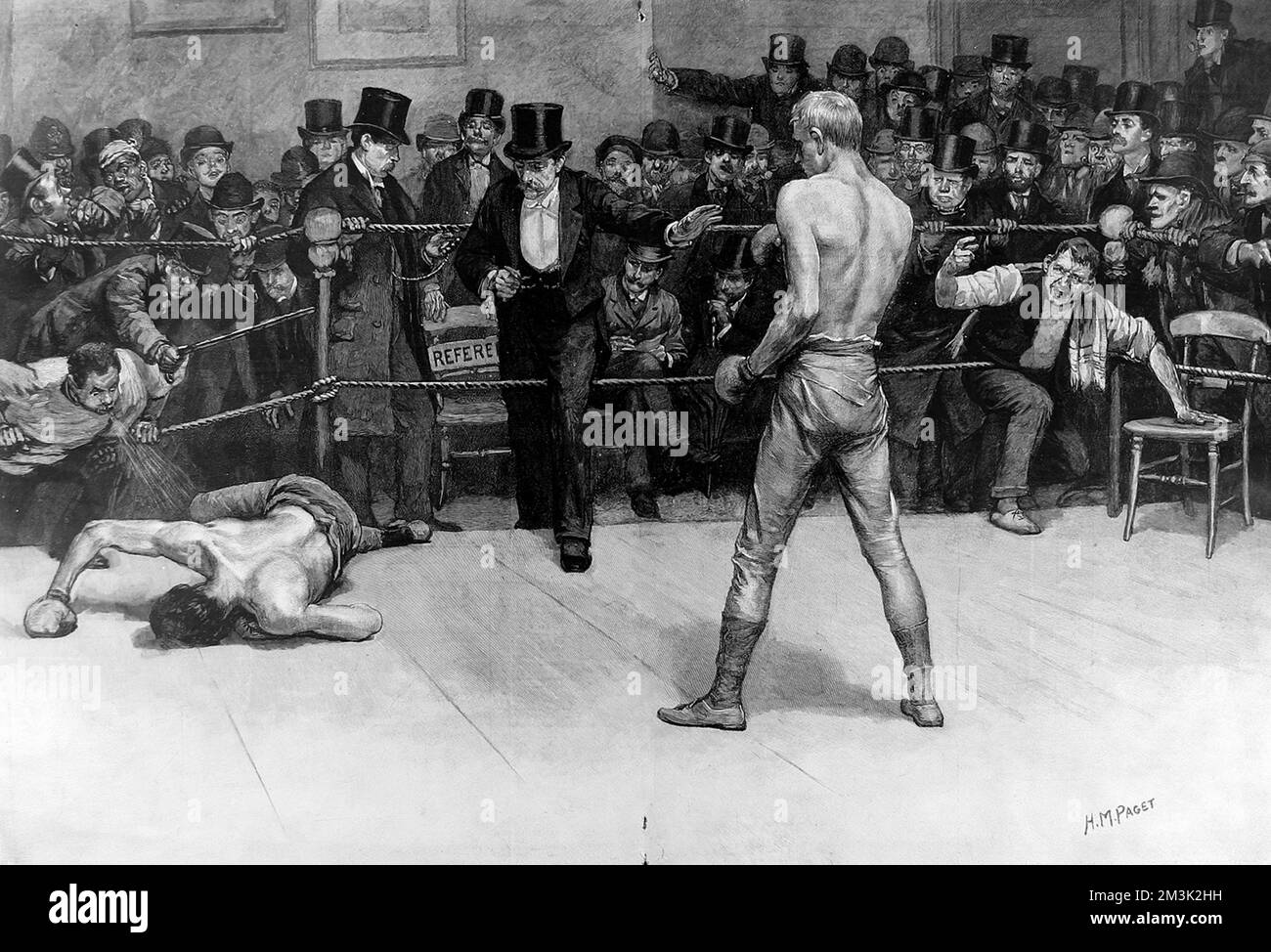 Das Ende eines Boxkampfes. Auf der linken Seite liegt der besiegte Boxer auf dem Boden, während der Schiedsrichter mit Zylinder den Ring betritt, um das Ende des Spiels zu markieren. Stockfoto