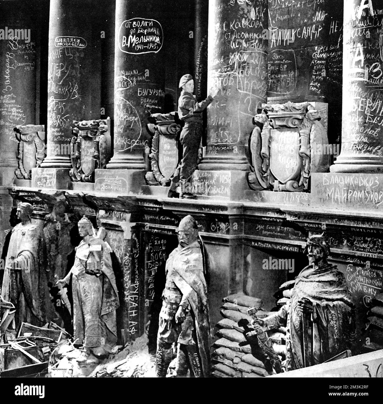 Britischer Soldat, der kurz nach dem Ende des Zweiten Weltkriegs in Europa, Juli 1945, eine Botschaft an die Mauern des Deutschen Reichstags setzt. Der größte Teil der auf diesem Bild sichtbaren Graffiti wurde von den siegreichen russischen Soldaten erschaffen, nachdem sie den letzten Nazi-Widerstand in Berlin niedergeschlagen hatten. Stockfoto