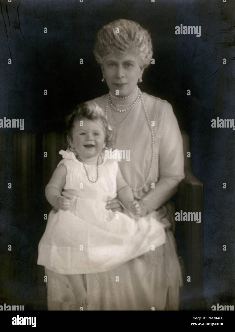 Königin Mary (Gemahlin von König George V.) hält kurz vor ihrem ersten Geburtstag ihre Enkelin Prinzessin Elizabeth of York (später Königin Elizabeth II.). Die Prinzessin wurde von ihren Großeltern betreut, während der Herzog und die Herzogin von York auf Tour in Australien waren. König George und Königin Mary waren angeblich distanziert von ihren eigenen Kindern, bewiesen aber, dass sie die Großeltern der Prinzessin anbeteten, die in der Familie als „Lilibet“ bekannt ist. Datum: April 1927 Stockfoto
