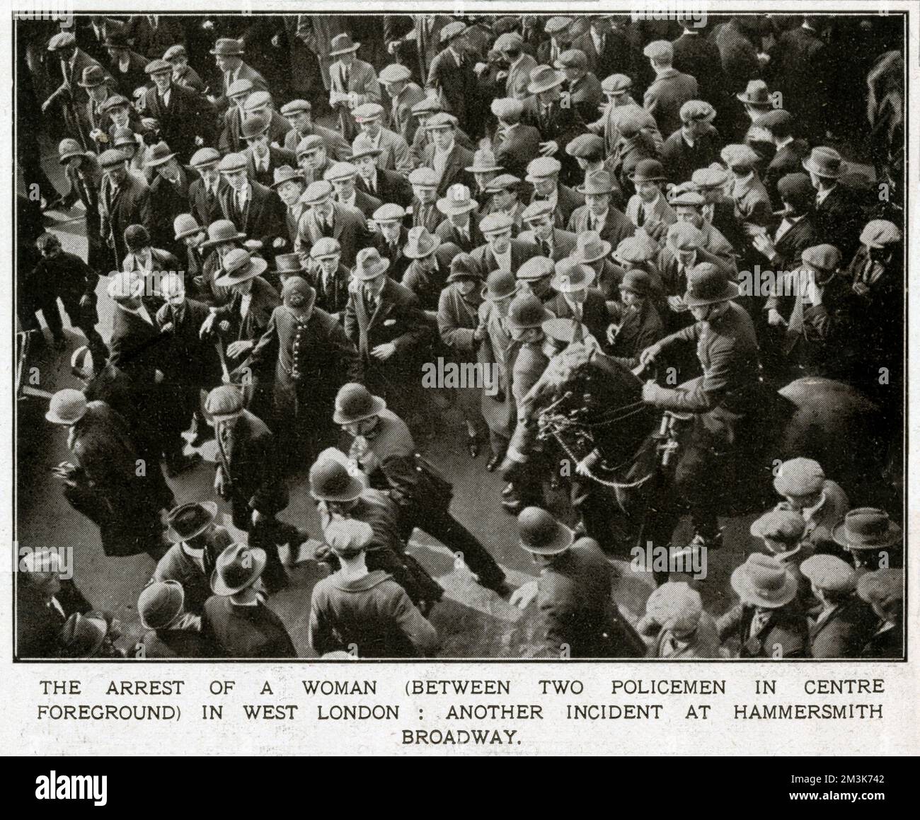 Die Verhaftung einer Frau (zwischen zwei Polizisten im Vordergrund) am Hammersmith Broadway in West London während des Generalstreiks. Obwohl es weitgehend friedlich war, gab es während des Streiks immer noch einige erhebliche Störungen. Zur Unterstützung eines Streiks der Bergleute wegen drohender Lohnkürzungen berief der Gewerkschaftskongress Anfang Mai 1926 einen Generalstreik ein. Der Streik betraf nur bestimmte wichtige Industriesektoren (Docks, Strom, Gas, Eisenbahnen), aber angesichts gut organisierter staatlicher Notfallmaßnahmen und fehlender wirklicher öffentlicher Unterstützung brach er nach neun Tagen 1926 zusammen Stockfoto