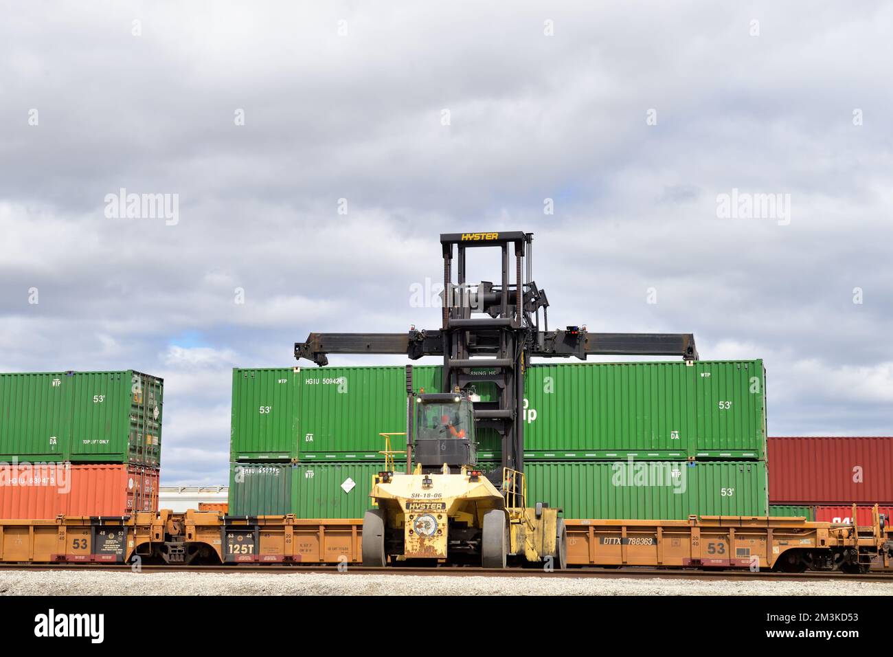 Franklin Park, Illinois, USA. Eine Gabelhubvorrichtung, die auf Containereinheiten an Bord eines Güterzugs in einer intermodalen Einrichtung auf einem Eisenbahnhof zugreift. Stockfoto