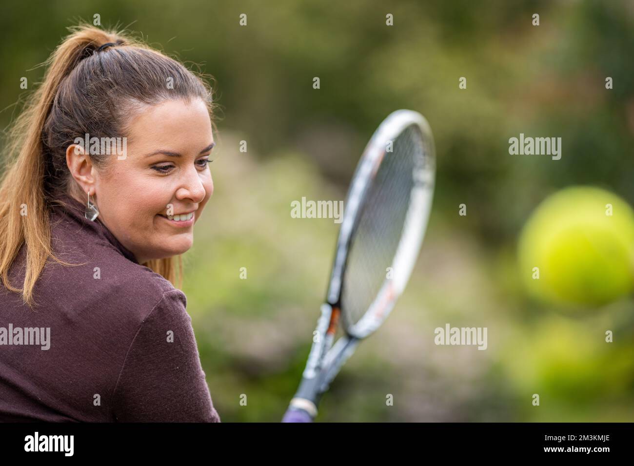 Tennisspielerin, die auf einem Rasenplatz in england Vorder- und Tennisbälle schlägt Stockfoto