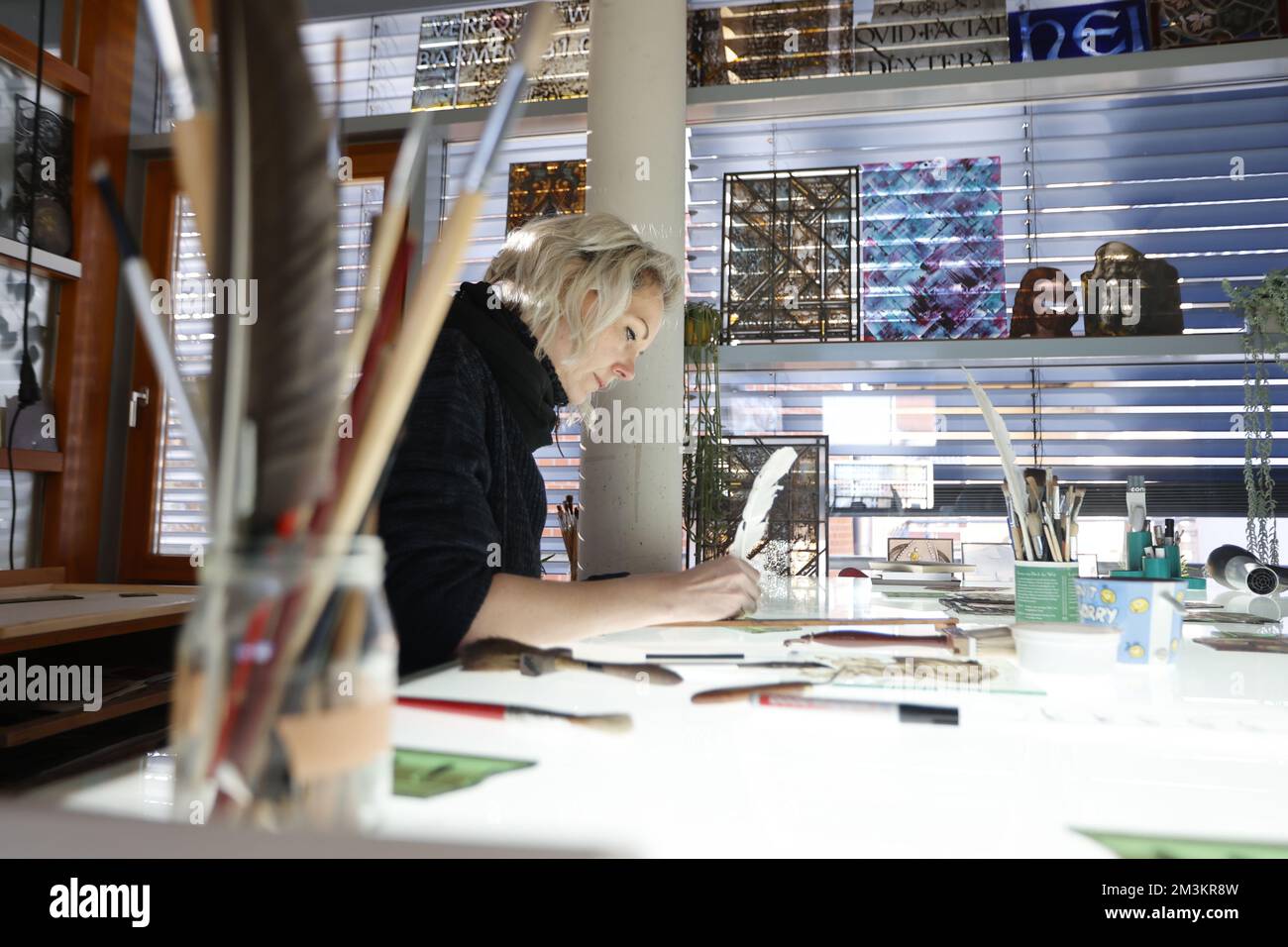 15. Dezember 2022, Sachsen-Anhalt, Quedlinburg: Restauriererin Petra Ullrich verwendet eine Ätztechnik mit einem Federstift, um in der Schneemelcher-Glaswerkstatt in Quedlinburg an einem bleihaltigen Glasfenster zu arbeiten. Die Glaswerkstatt besteht seit 1886 und wird von der vierten Generation der Schneemelcher-Familie betrieben. Nach eigenen Angaben ist das Unternehmen eine der größten Glasmalerei in Deutschland. Das Angebot des traditionellen Unternehmens umfasst künstlerische Glasveredelung, Restaurierung von Buntglas und bleihaltigem Glas sowie Flur- und Industrieglasung. Unter den ch Stockfoto 15. Dezember 2022, Sachsen-Anhalt, Quedlinburg: Restauriererin Petra Ullrich verwendet eine Ätztechnik mit einem Federstift, um in der Schneemelcher-Glaswerkstatt in Quedlinburg an einem bleihaltigen Glasfenster zu arbeiten. Die Glaswerkstatt besteht seit 1886 und wird von der vierten Generation der Schneemelcher-Familie betrieben. Nach eigenen Angaben ist das Unternehmen eine der größten Glasmalerei in Deutschland. Das Angebot des traditionellen Unternehmens umfasst künstlerische Glasveredelung, Restaurierung von Buntglas und bleihaltigem Glas sowie Flur- und Industrieglasung. Unter den ch Stockfoto