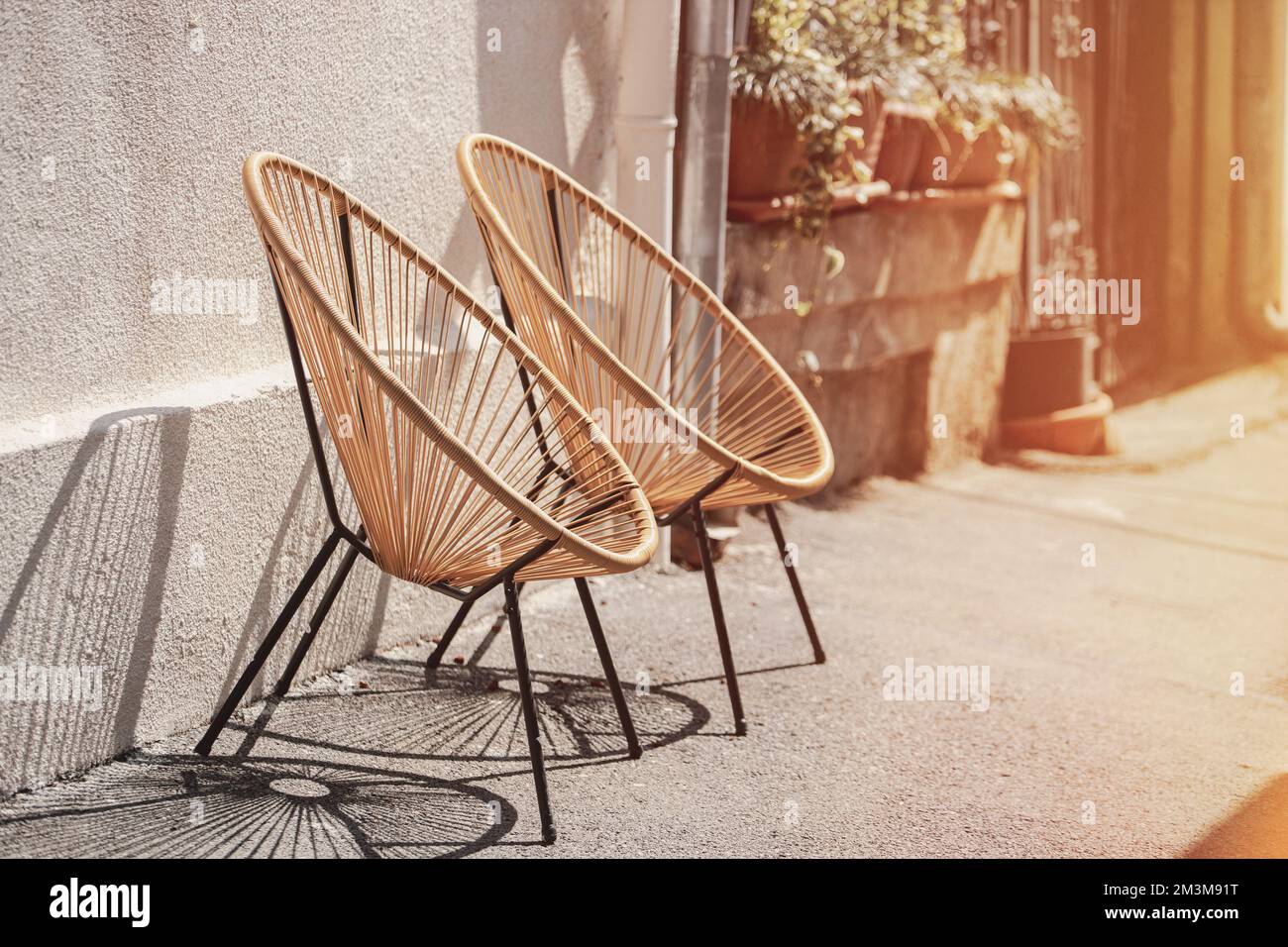Rattan-Korbsessel. Korbsessel Stehen Draußen. Moderne Möbel An Der Straße. Cafe-Möbel. Trendige Designer-Stühle. Designer-Sessel Stockfoto