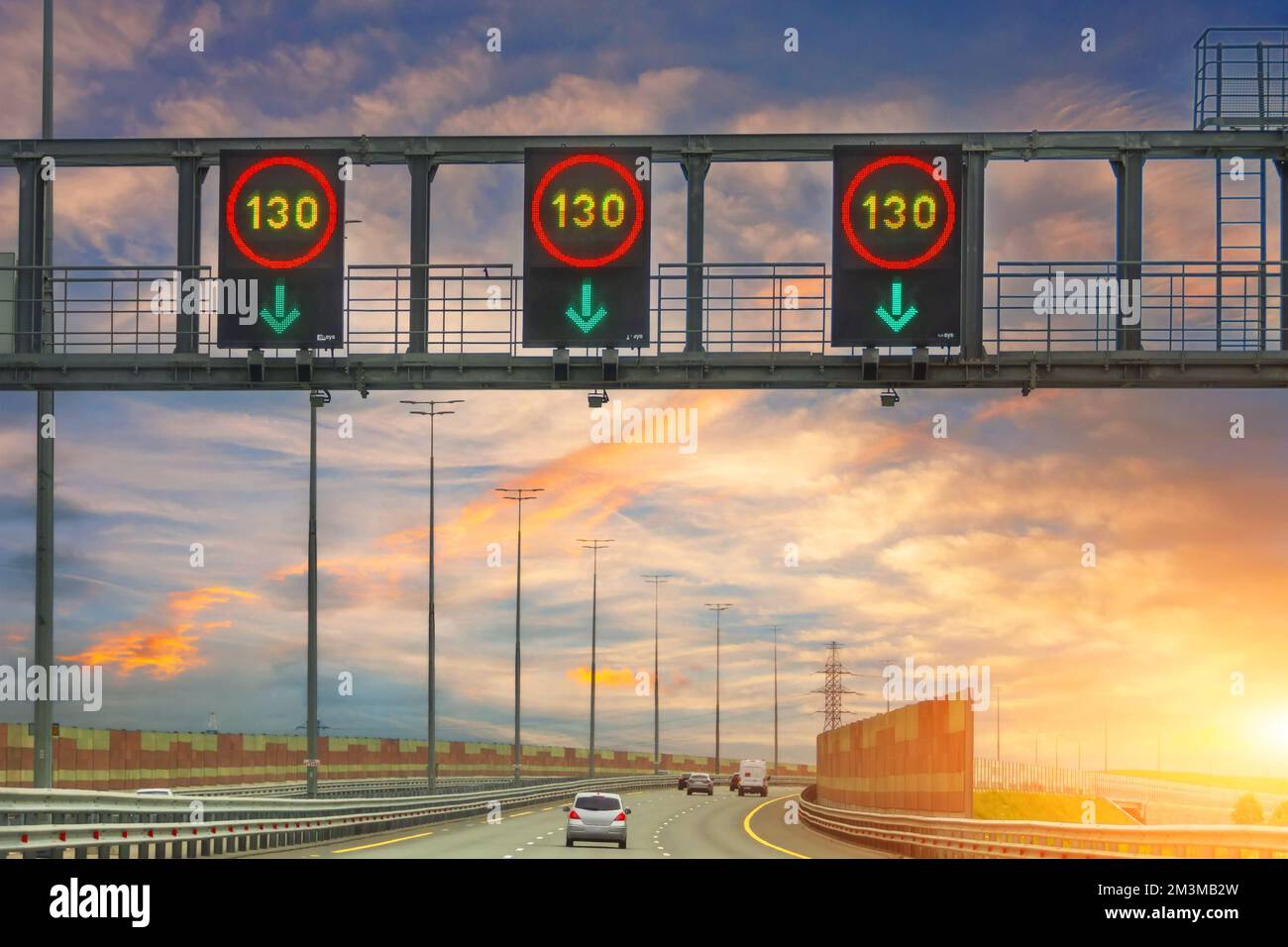 Leuchtende Schilder mit einer Mindestgeschwindigkeit von 130 km/h am Morgen bei Sonnenaufgang Stockfoto