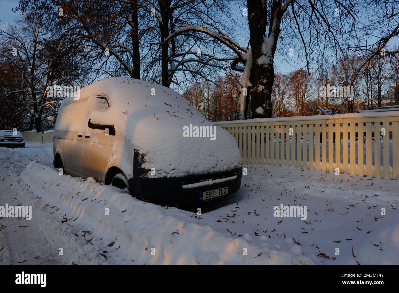 Ein Auto, das früh am Morgen unter Schnee auf der Tartu Street begraben wurde. Estland 2022 Stockfoto