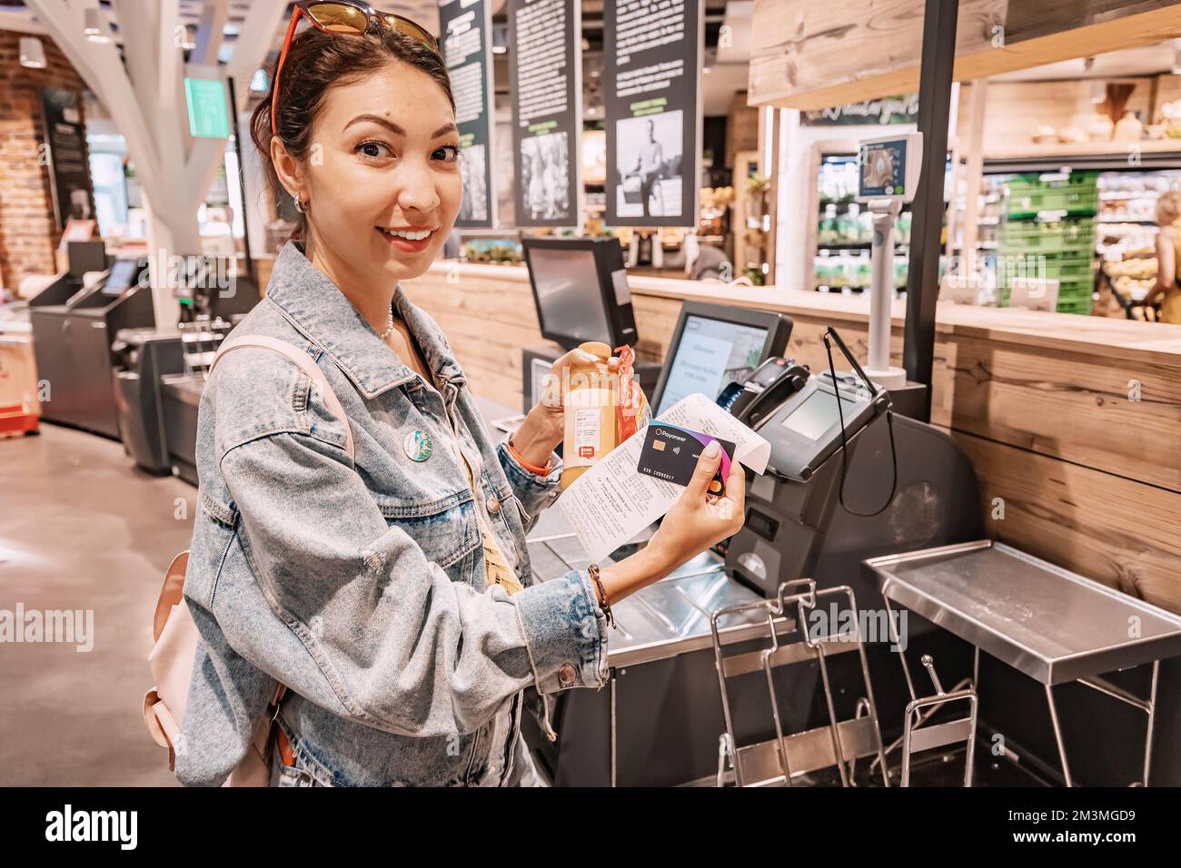 30. Juli 2022, Köln, Deutschland: Weibliche Käufer belastet das POS-Terminal mit einer Kreditkarte, um Einkäufe an der Self-Service-Kasse zu bezahlen Stockfoto