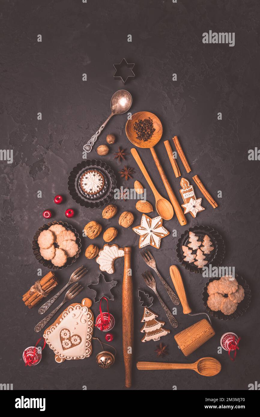 Feiertage, Feiern und Kochkonzept - Weihnachtsbaum aus Lebkeksen, Backzutaten und Küchenutensilien. Neujahr und Chili Stockfoto