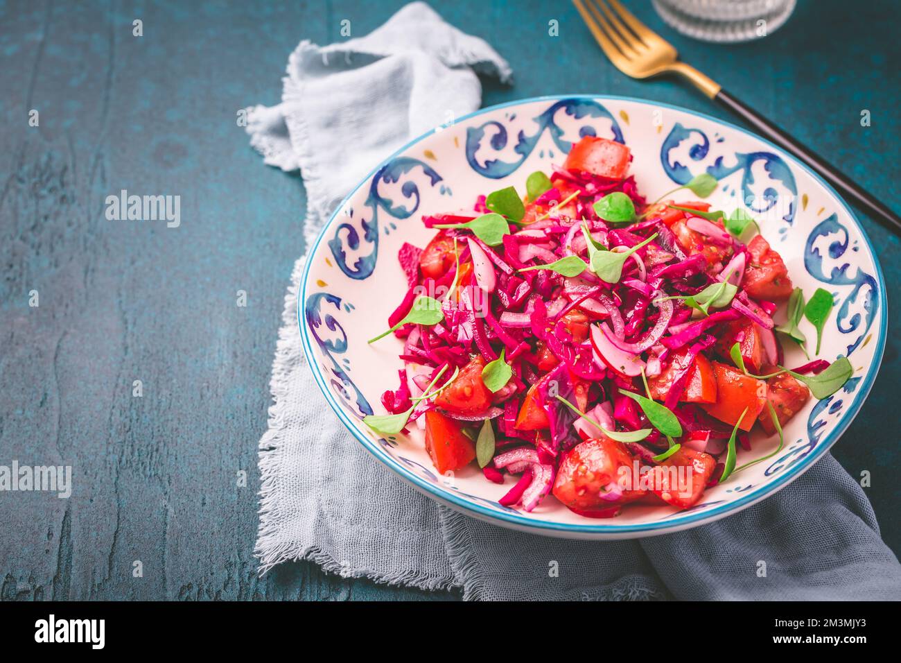 Wintersalat: Eingelegter Rotkohlsalat mit Rettich, Tomaten, Zwiebeln und Winterportulak. Vegetarisches gesundes Essen. Stockfoto