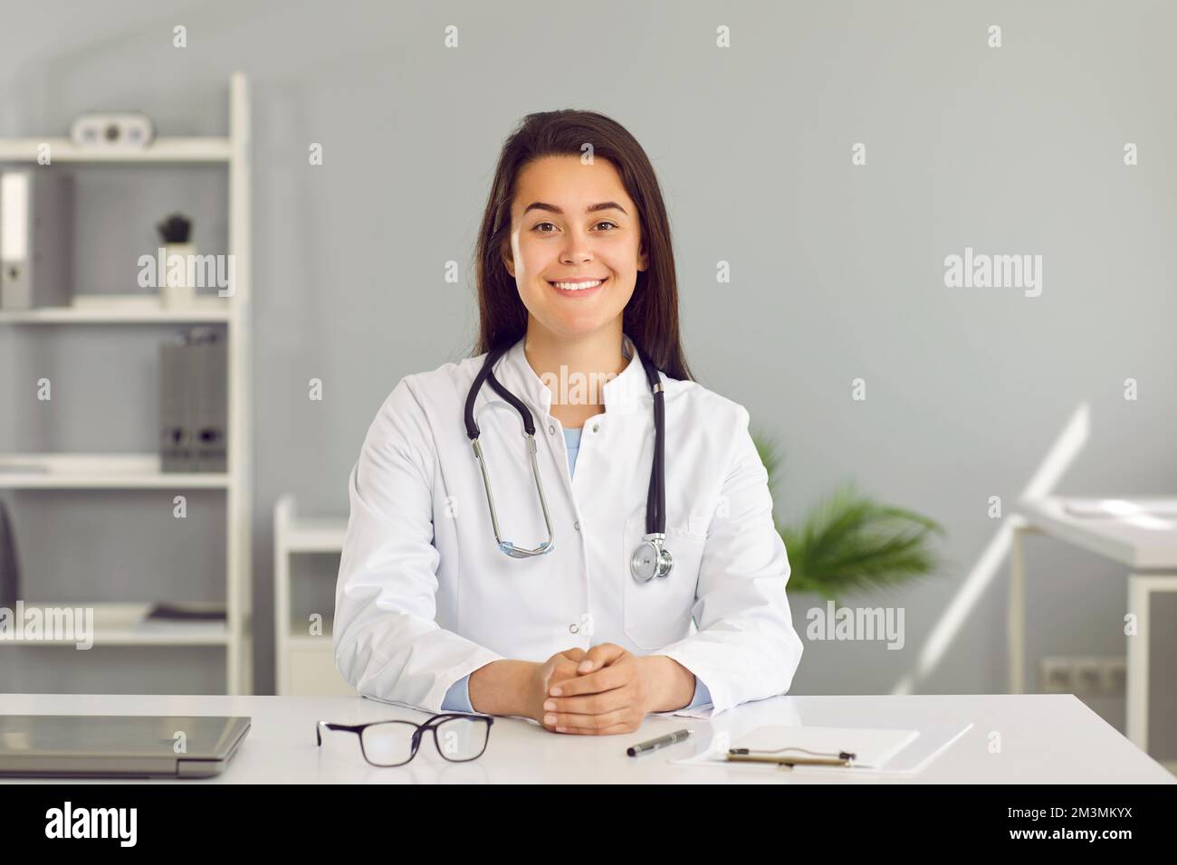 Freundliche junge Ärztin, die ihre Patienten über einen Videolink online konsultiert. Stockfoto