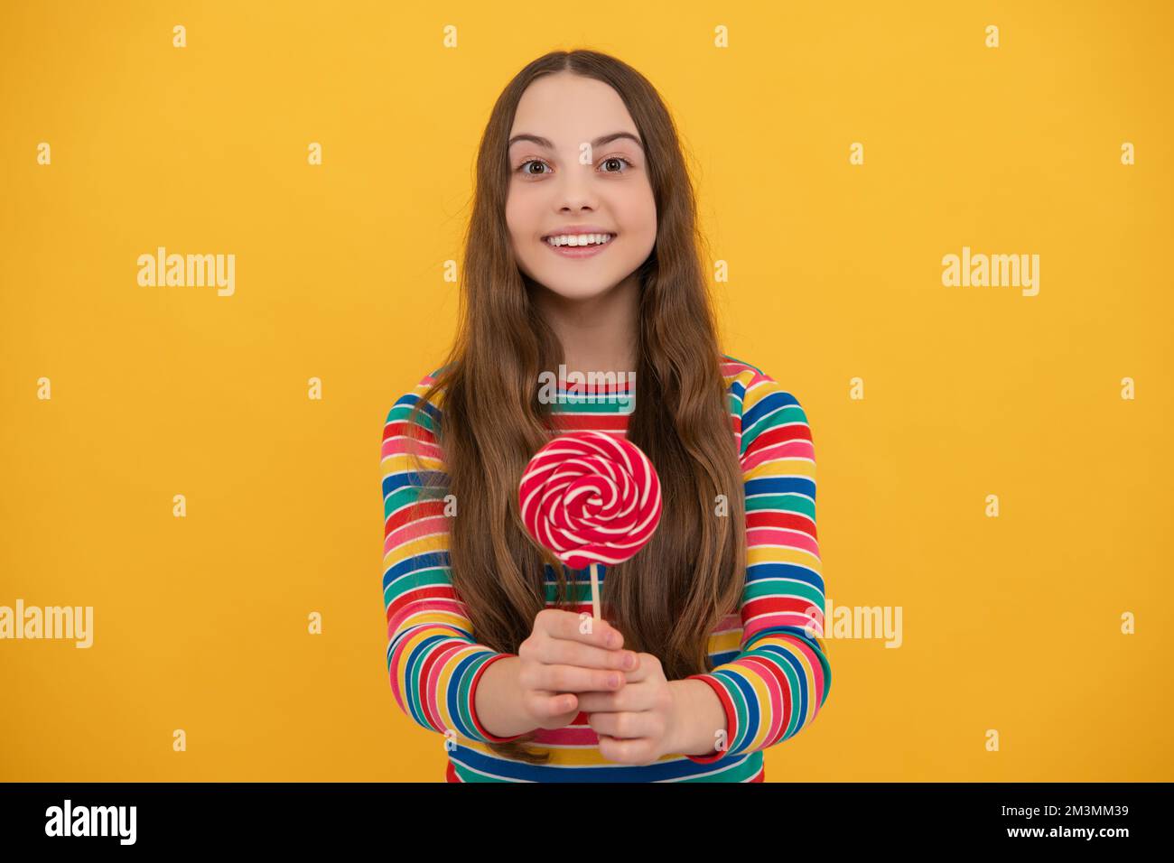 Teenager-Mädchen mit Süßigkeiten Lollipop, glückliches Kind 12, 13, 14 Jahre alt essen großen Zucker Lollipop, Süßigkeiten Süßigkeiten. Stockfoto