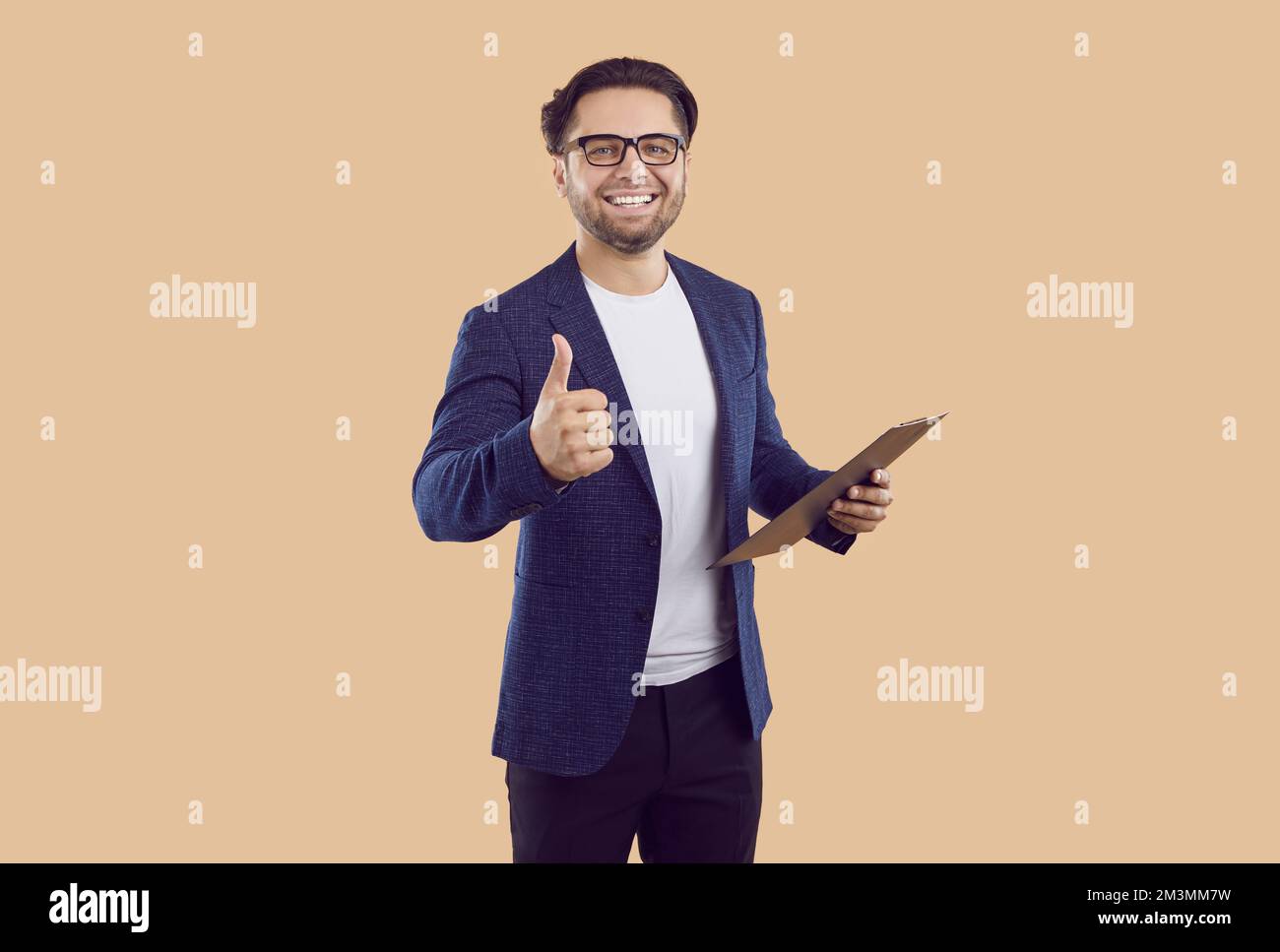 Erfolgreicher Business Agent oder Vertriebsleiter mit Clipboard, Daumen hoch und lächelnd Stockfoto