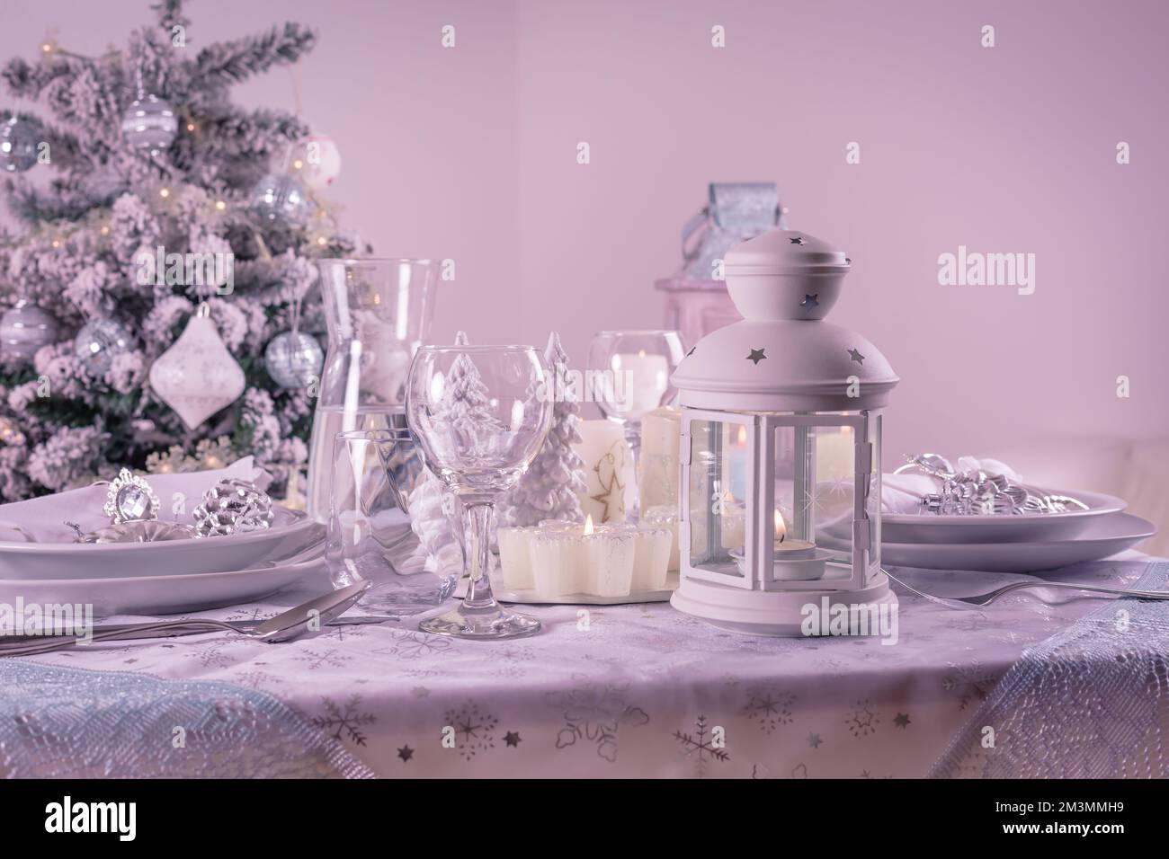 Festlicher Weihnachtstisch mit Besteck, Kerzen und dekoriertem Weihnachtsbaum Stockfoto