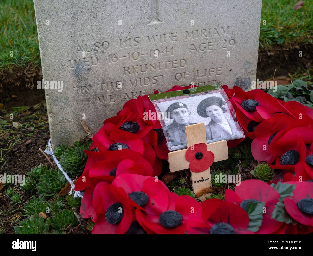 WW1 Grabstein auf dem Towcester Road Cemetery, Northampton, Großbritannien; ungewöhnlich mit dem Namen der Frau des Soldaten, mit Foto und Mohnkranz eingraviert. Stockfoto
