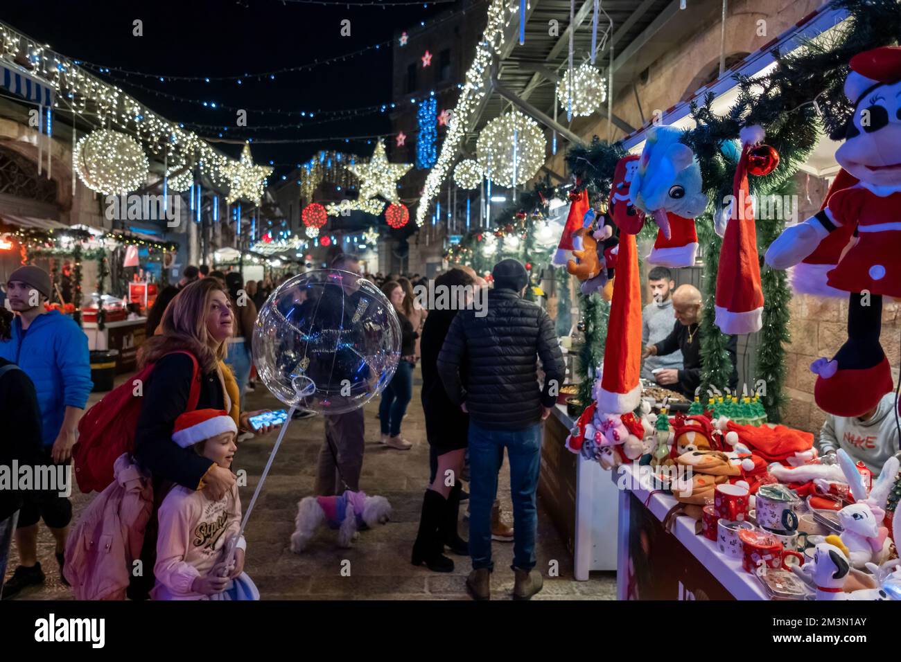 Die Menschen spazieren nachts durch den Weihnachtsmarkt in der Straße Bab el Gadid im christlichen Viertel der Altstadt in Jerusalem, Israel Stockfoto