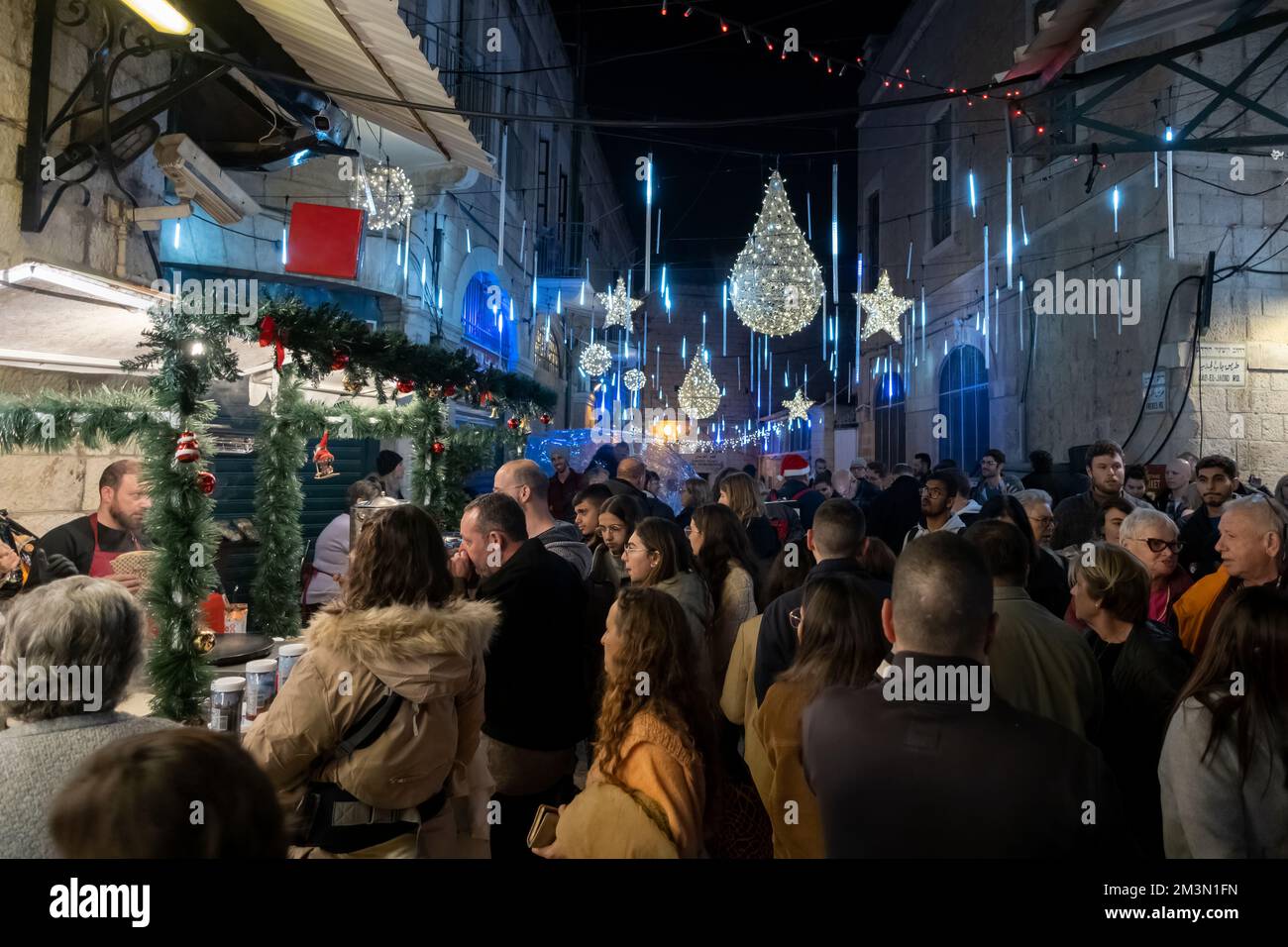 Die Menschen spazieren nachts durch den Weihnachtsmarkt in der Straße Bab el Gadid im christlichen Viertel der Altstadt in Jerusalem, Israel Stockfoto