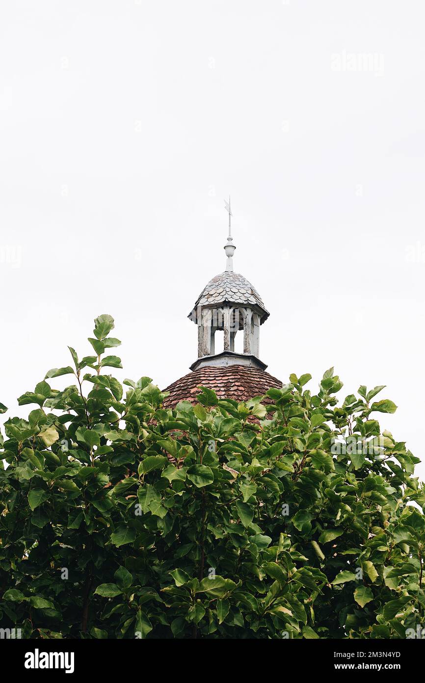 Ein vertikales Bild eines alten, antiken Glockenturms mit Wetterfahne oben in Frankreich Stockfoto