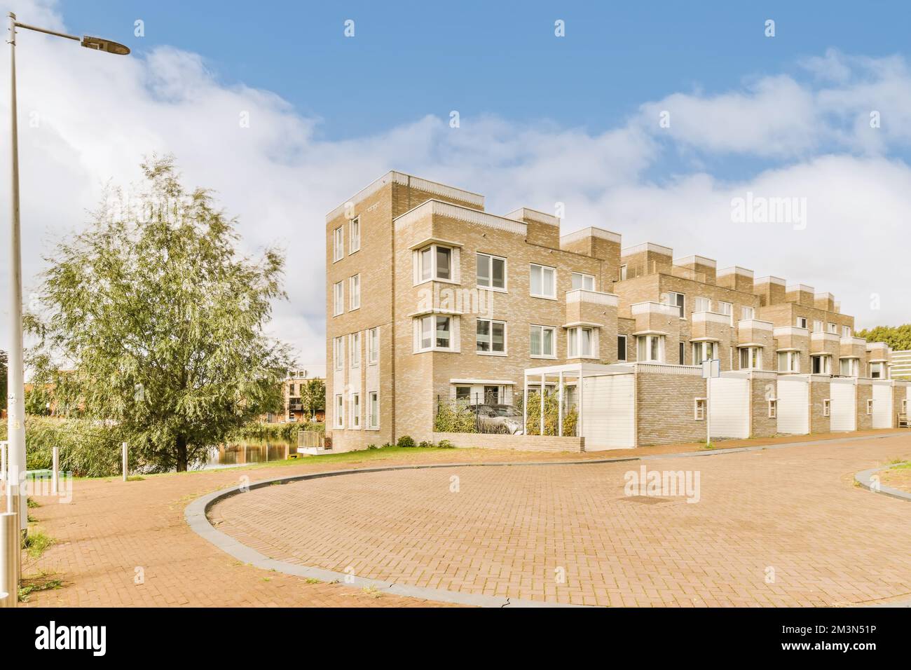 Ein Apartmentkomplex in den Vororten von johannesburg, mit Backsteinauffahrten und Bäumen auf beiden Seiten Foto von crediton/Shutterstocker Stockfoto
