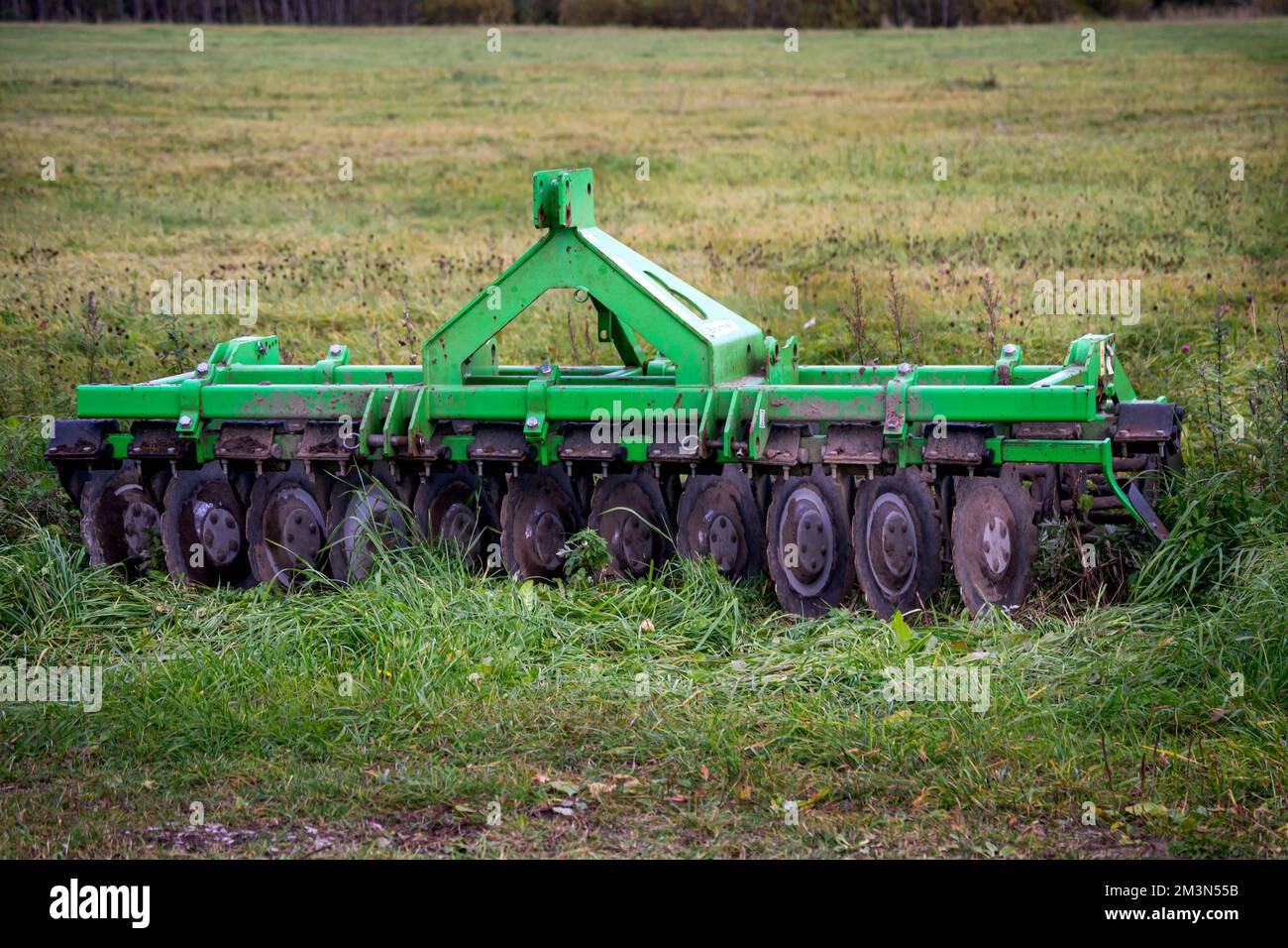 Ein alter Metallpflug wird in ein Feld in einem Dorf geworfen. Stockfoto