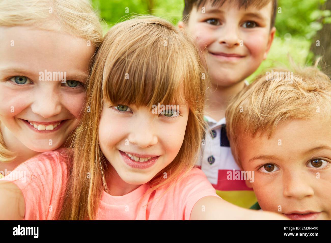 Glückliche Multirassenmädchen und -Jungen, die während der Sommerferien Selfie im Park machen Stockfoto