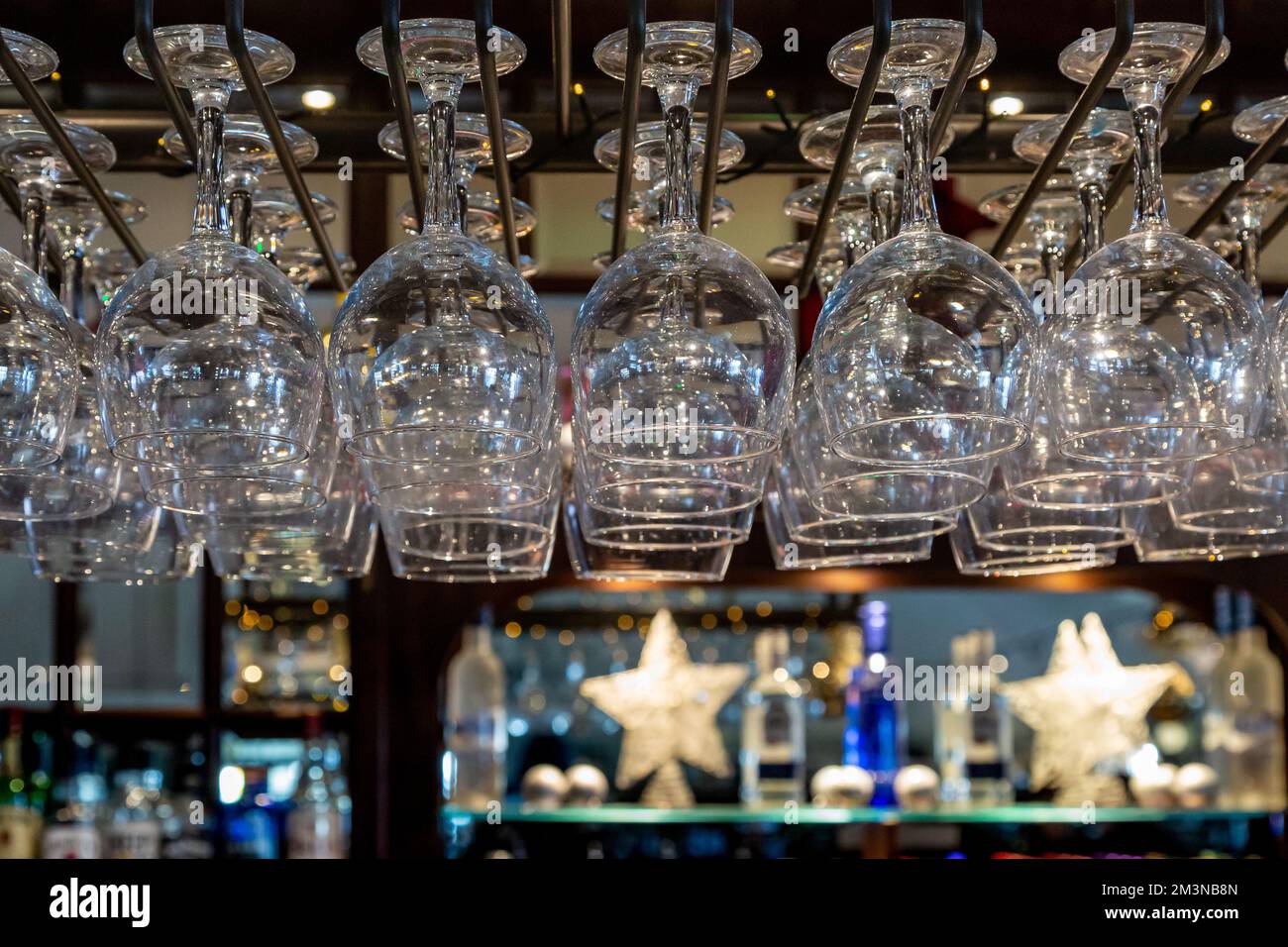 Die Gläser hängen an einer Bar auf, mit geringer Schärfentiefe Stockfoto