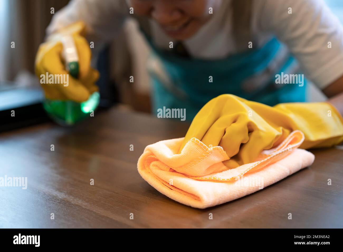 Ein Teil einer Frau, die zu Hause einen Küchentisch sauber macht. Bild einer jungen Haushälterin, einer Reinigungskraft oder einer Hausarbeit. Stockfoto