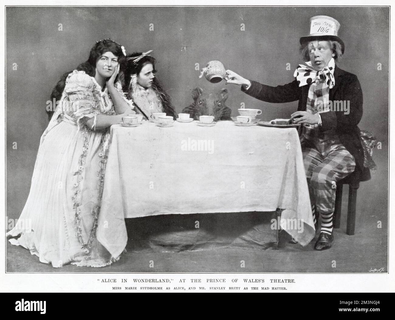 „Alice im Wunderland“ Teeparty der verrückten Hatters mit Marie Studholme als Alice und Stanley Brett als der verrückte Hutmacher im Prince of Wales Theatre, West End, London. Stockfoto