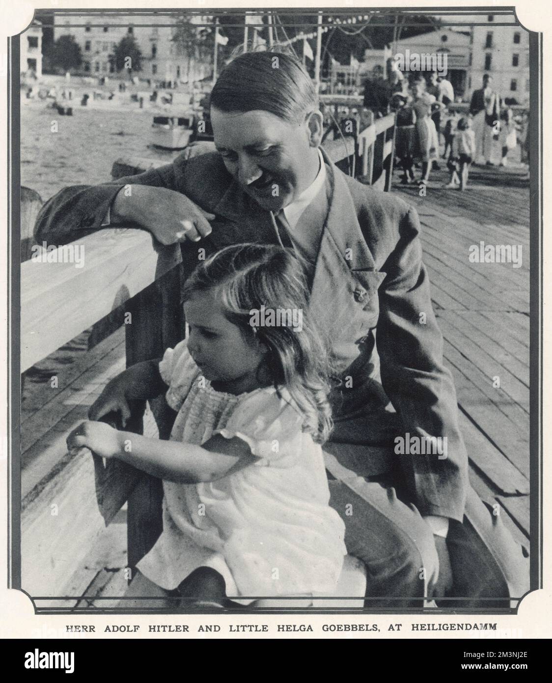 Herr Adolf Hitler und die kleine Helga Goebbels am Heiligendamm. Hitler sitzt auf einer Bank neben Helga, der ältesten Tochter von Joseph Goebbels (auf diesem Foto 3 Jahre alt), im Badeort Heiligendamm an der Ostsee. Datum: 1935 Stockfoto