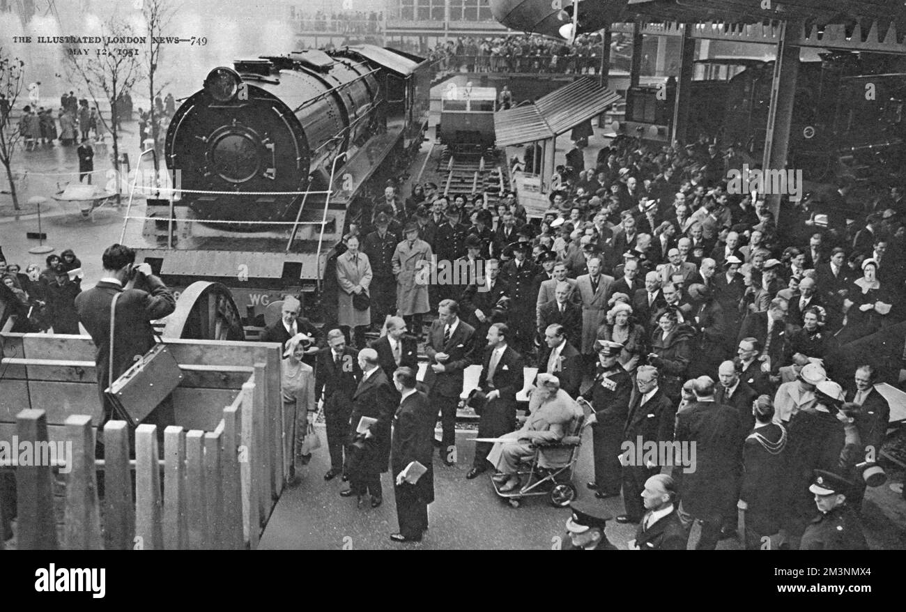 Erleben Sie einen königlichen Besuch im Transport Pavilion, Teil des Festivals of Britain an der South Bank, London. Hier sehen König George VI., Königin Elizabeth, Königin Mary (im Rollstuhl) und andere Mitglieder der königlichen Familie eine Eisenbahnlokomotive. Datum: 4. Mai 1951 Stockfoto