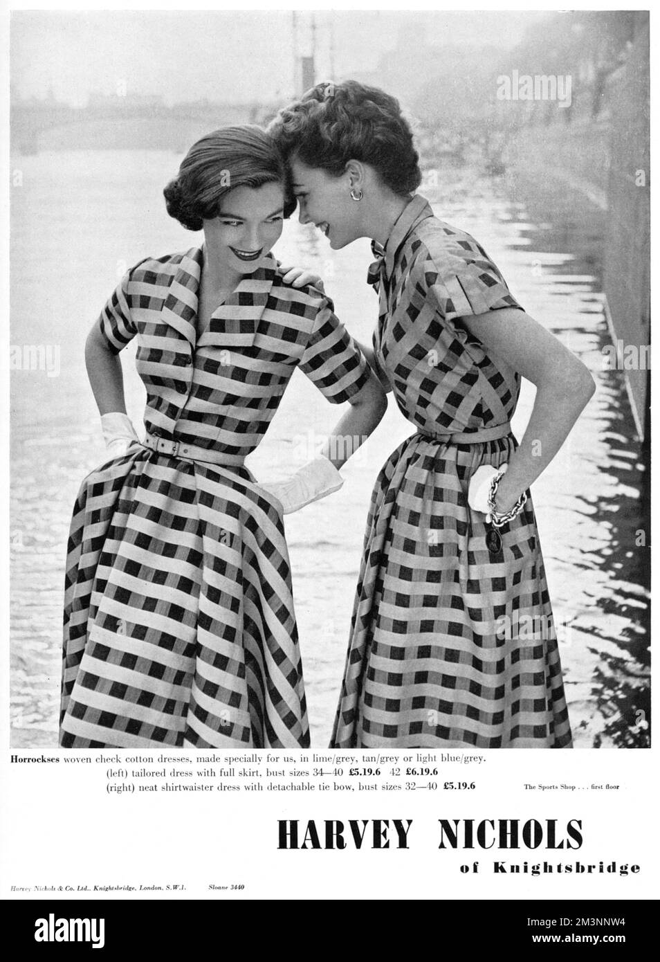 Zwei Freunde, die sehr ähnliche karierte Baumwollkleider in Horrockses-Stoff tragen, teilen einen Witz. 1953 Stockfoto