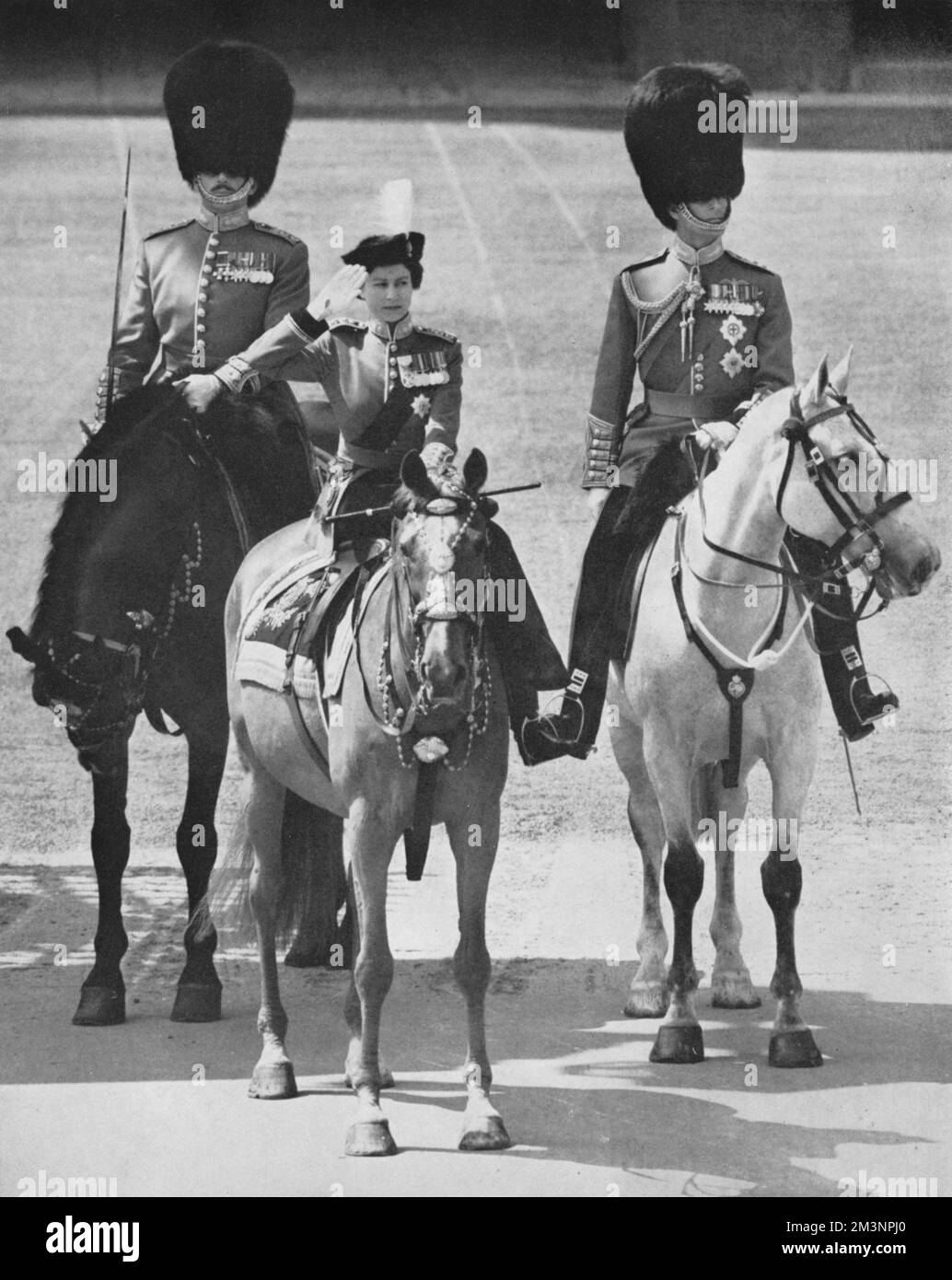 Die Königin begrüßt die Teilnahme an der Geburtstagsparade im Buckingham Palace nach der feierlichen Trooping of the Colour. Sie trägt die Uniform der Grenadiergarde. Datum: 1956 Stockfoto