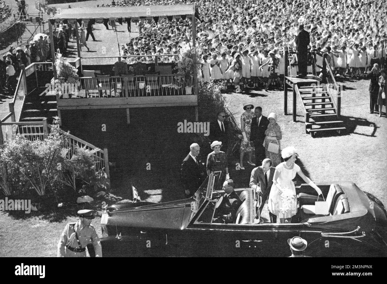 Königin Elizabeth II. Und Prinz Philip verlassen die Rennbahn im Victoria Park in Adelaide, nachdem ein Chor mit 3000 Kindern australische Lieder gesungen hat. Weitere 70.000 Kinder nahmen an der Veranstaltung Teil. Datum: 1963 Stockfoto